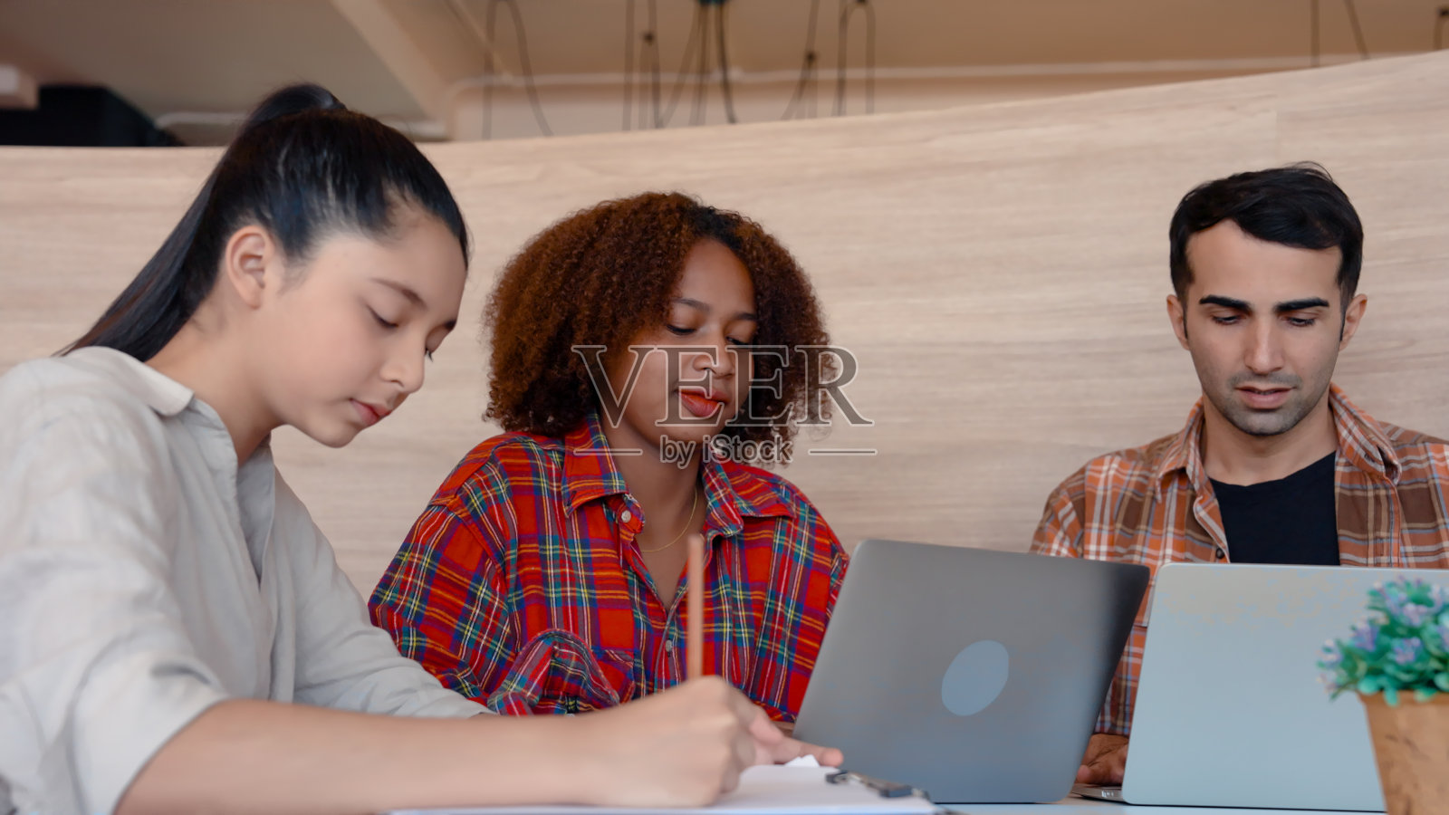 特写非洲女孩的脸,周末和她的亚洲朋友坐在一起补习,男老师详细解释,他们可以理解他们感兴趣的是什么,可以继续学习。照片摄影图片