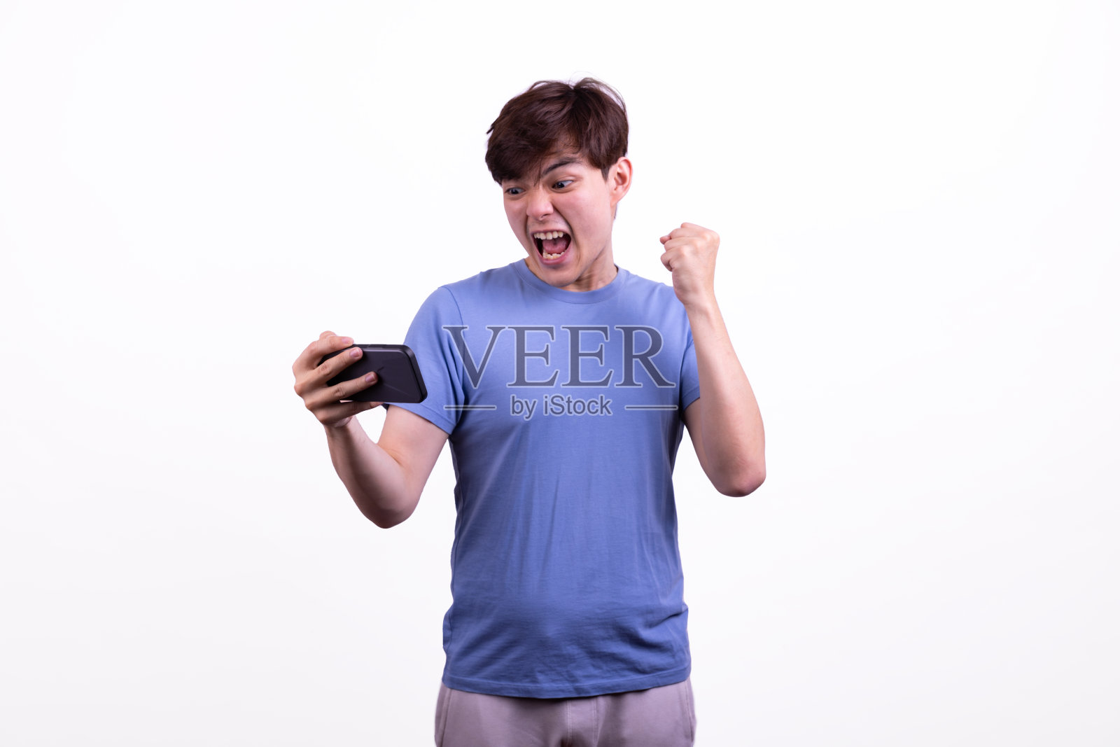 亚洲人赢了手机,白色背景。照片摄影图片