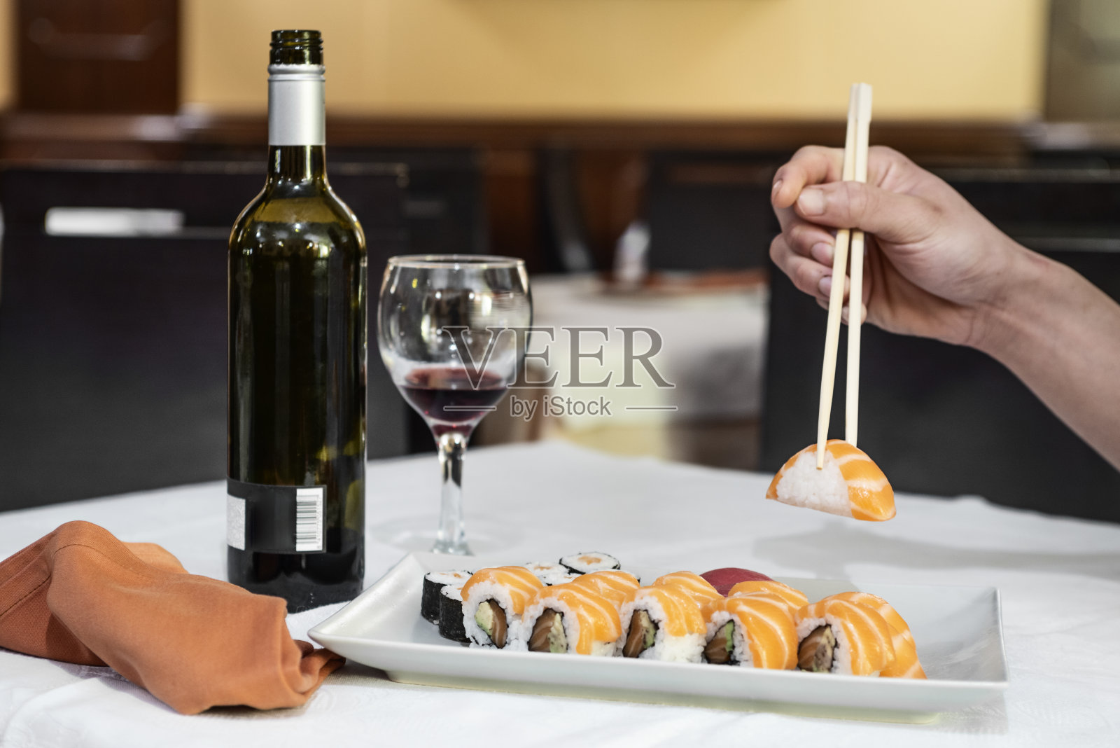 用筷子夹着三文鱼寿司的手照片摄影图片