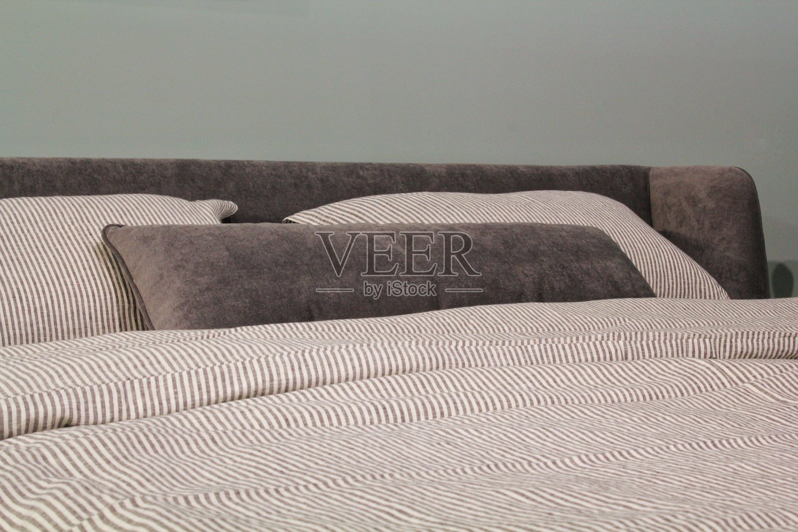 床上舒适的彩色软枕头特写。时尚新潮的公寓家居装饰。Hygge斯堪的纳维亚阁楼设计照片摄影图片