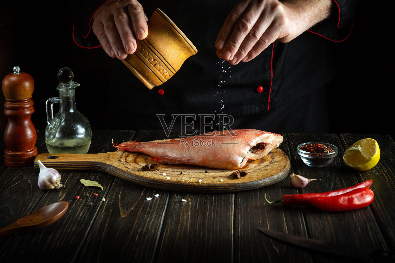 厨师在烘焙前先在厨房里给新鲜的面粉加盐。将餐厅或酒店的菜单或美味食谱放在深色背景上的想法。照片摄影图片