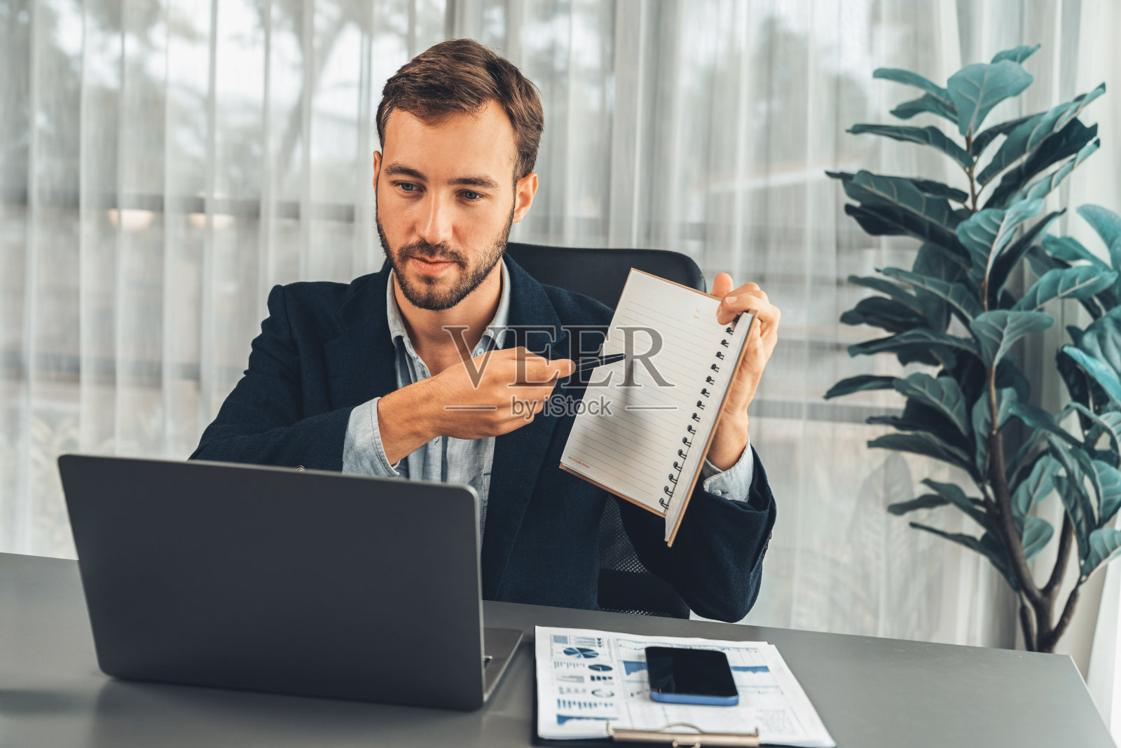 商人在办公桌上举行虚拟在线办公会议。实体照片摄影图片