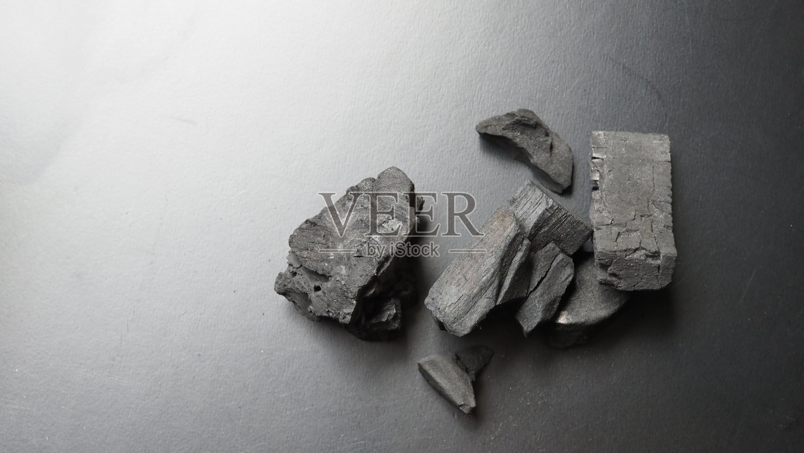 天然木炭传统木炭或硬木炭在木制桌面视图。生火的木炭材料,用于烧烤或户外聚会。黑色木炭近景俯视图。照片摄影图片