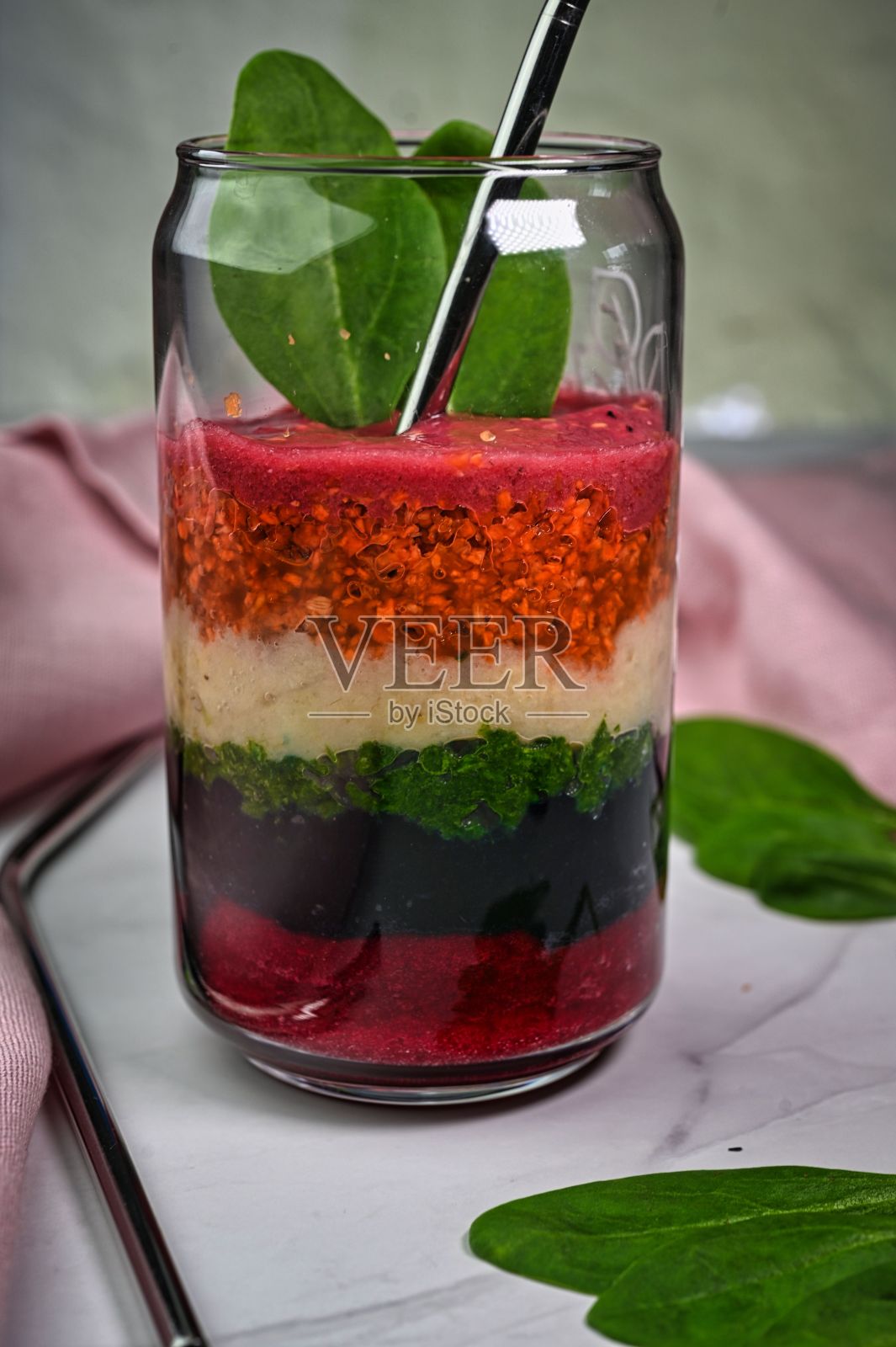 一杯充满活力的彩虹色冰沙,由新鲜水果和蔬菜制成照片摄影图片