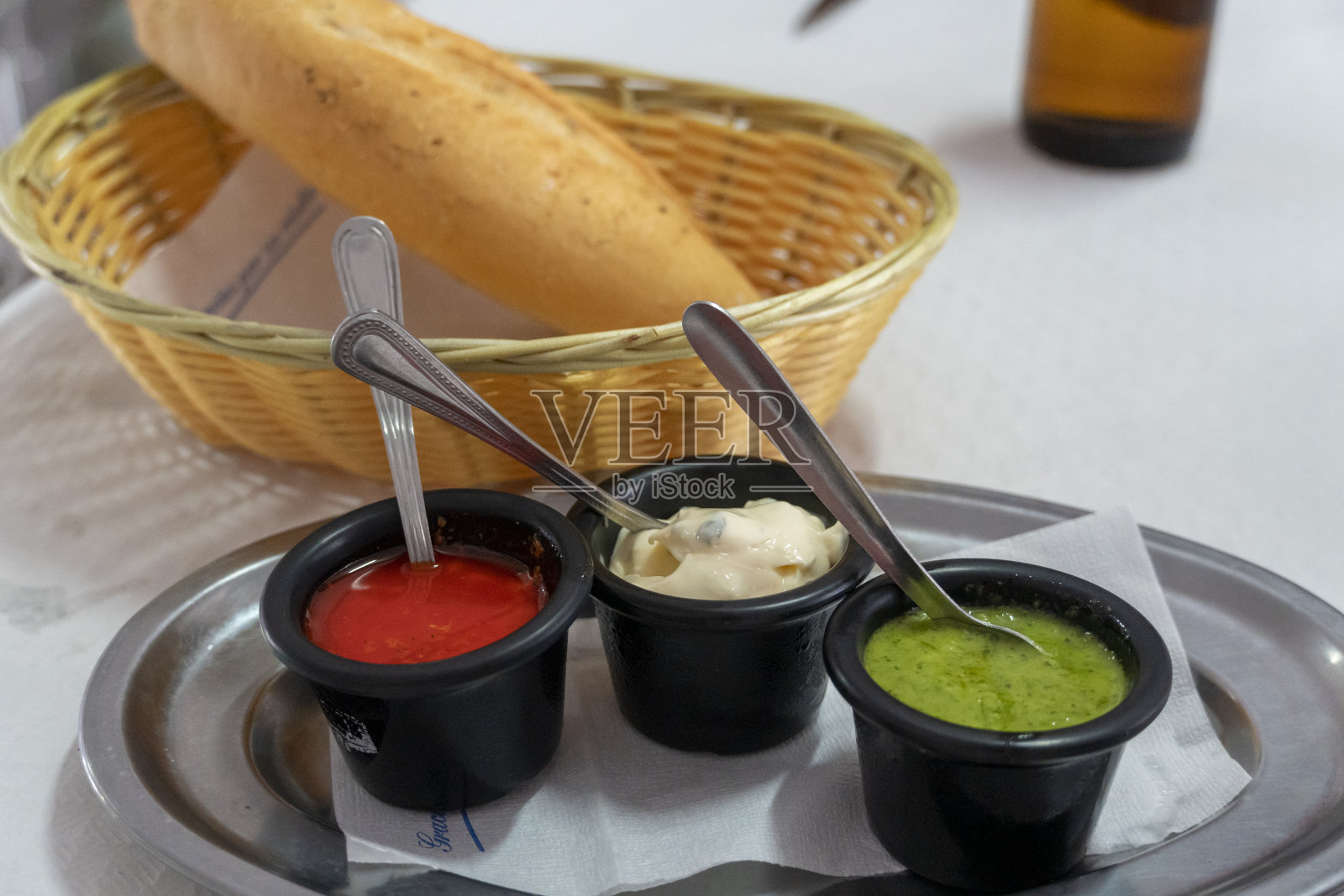 加那利群岛菜Papas Arrugadas皱纹土豆与Mojo picon红辣酱和Mojo verde绿酱在餐厅的桌子上照片摄影图片