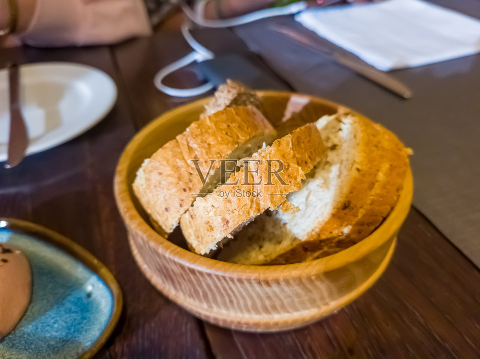 切片面包放在木盘上,全麦面包放在木盘上,裹上麻布,全麦面包照片摄影图片