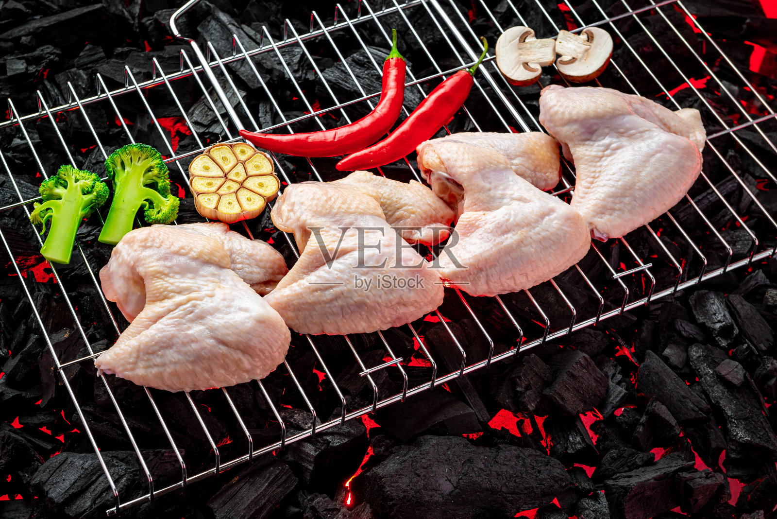 烤架上的生鸡翅,烤架上的热炭照片摄影图片