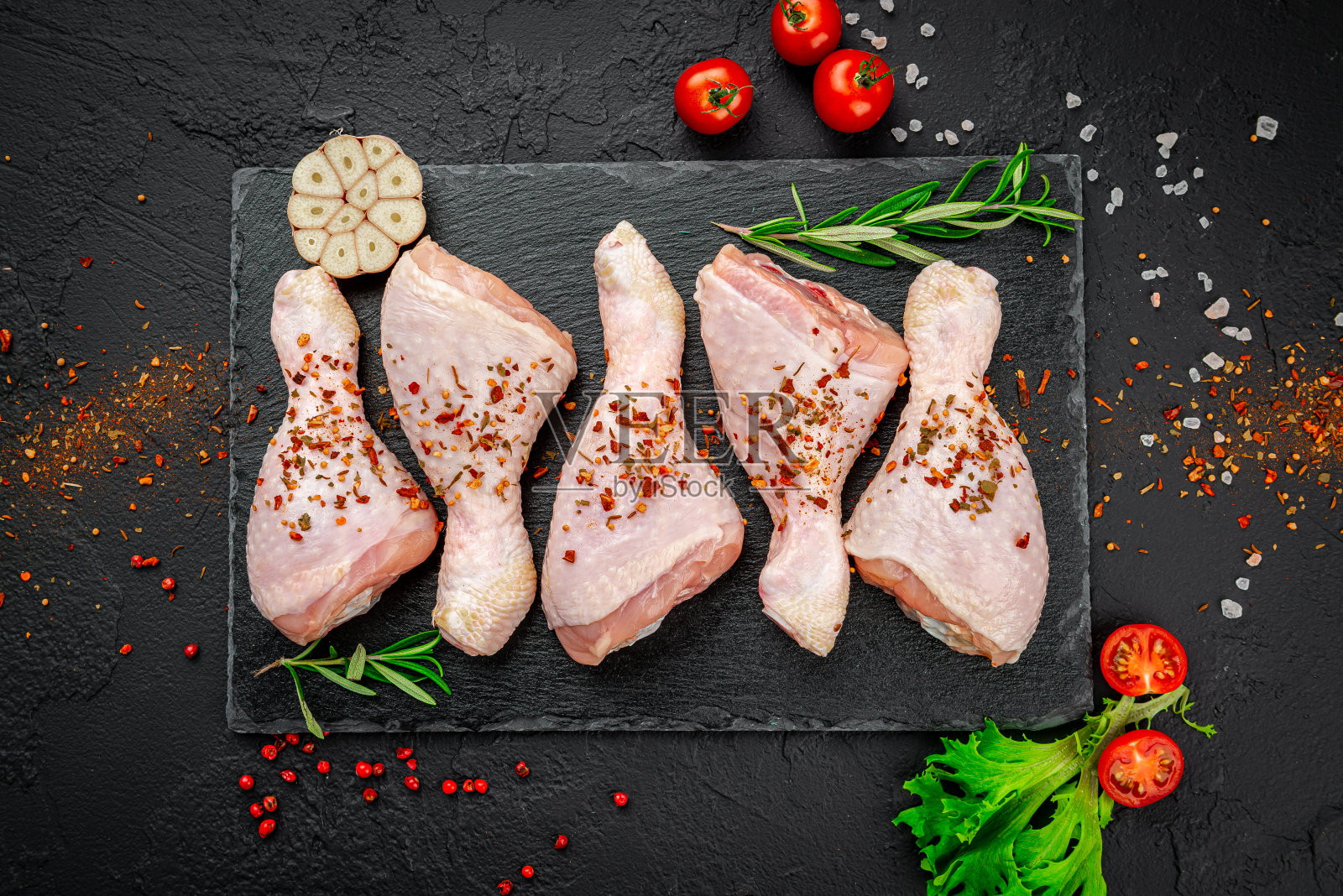 加香料和蔬菜的生鸡腿。照片摄影图片