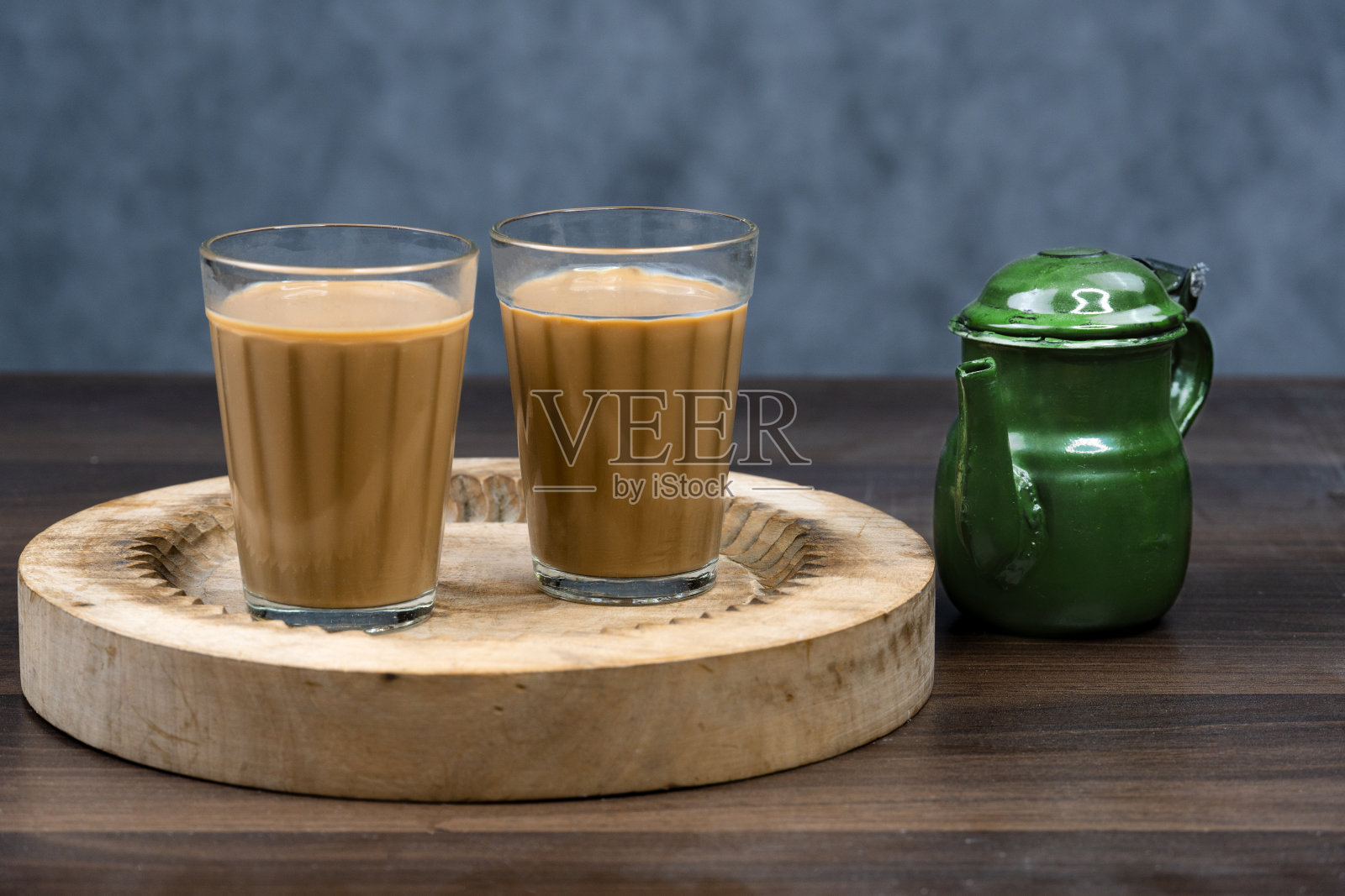 卡拉克奶茶杯配chanak茶壶,著名的印度茶,在纹理背景上照片摄影图片