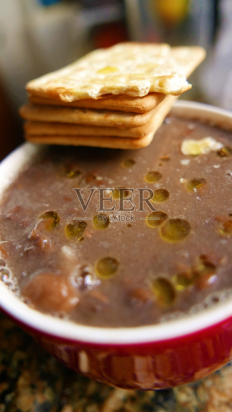 一大杯煮熟的豆子。大杯炖豆(Feijoada)。烤豆可以吃了。吃豆子的时候夹着饼干、橄榄油和米饭照片摄影图片