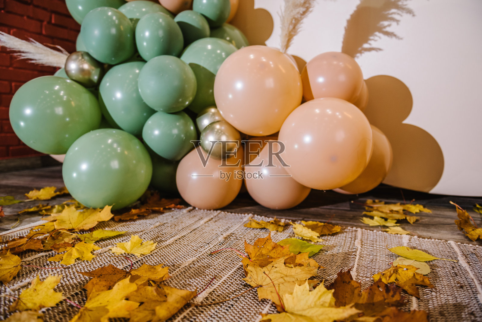 细节拱门装饰绿色、棕色、金色的气球、干树叶,供婚礼仪式使用。生日宴会的接待。庆祝洗礼。时髦的秋季装饰。照片墙装饰文字空间。照片摄影图片