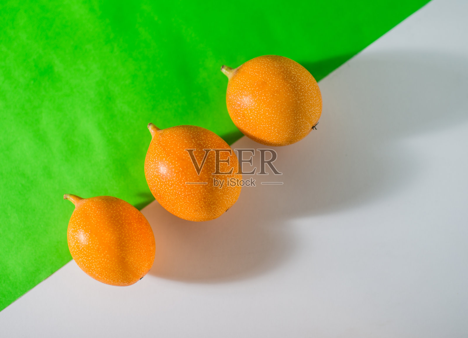 在白色和绿色背景上的石榴静物,在极简主义背景上的热带石榴特写照片摄影图片