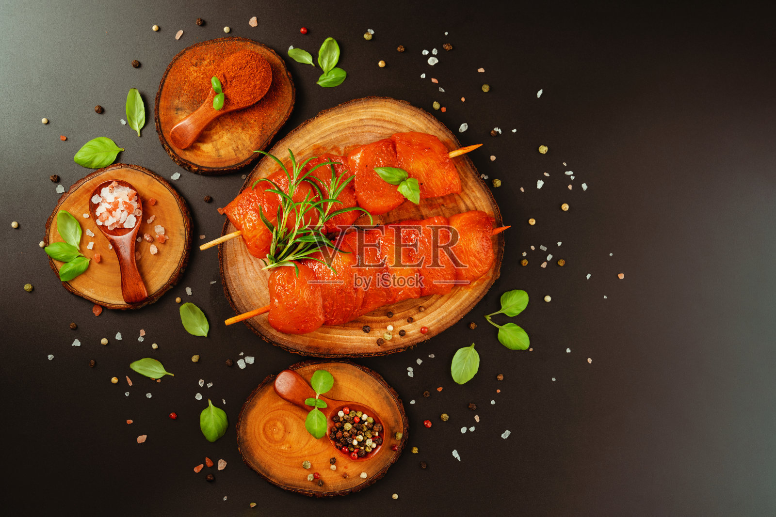 食品的概念。前视图。鸡胸片。新鲜的生腌鸡肉串与新鲜的香草在黑色的背景。鸡肉的特写。设计师采购。照片摄影图片