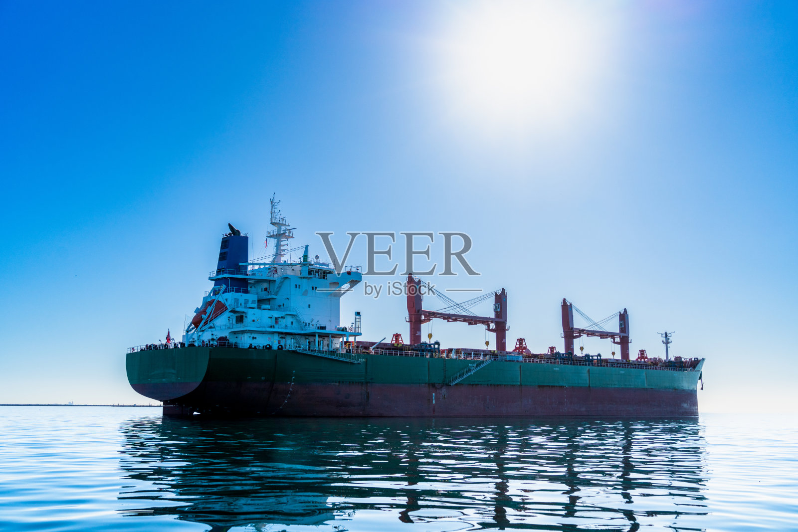 这艘巨大的油轮停靠在繁忙的洛杉矶港,高耸于其他船只之上。当它装卸原油货物时,空气中充满了燃料的气味。照片摄影图片