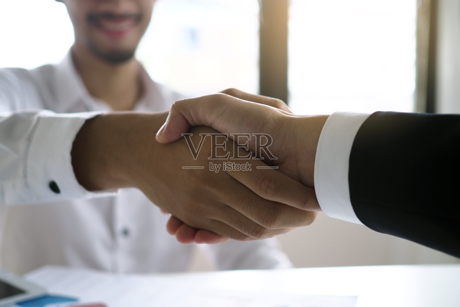 商人们握手言和,投资建筑和住宅项目,分享利润。有具有法律效力的合同文件吗照片摄影图片