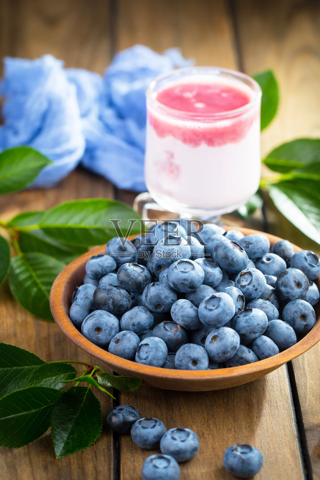 蓝莓放在杯子里,背景是旧的。照片摄影图片