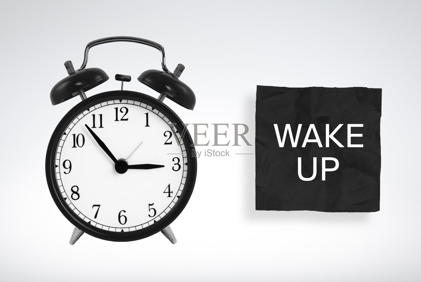 黑色闹钟和纸条提醒:起床照片摄影图片