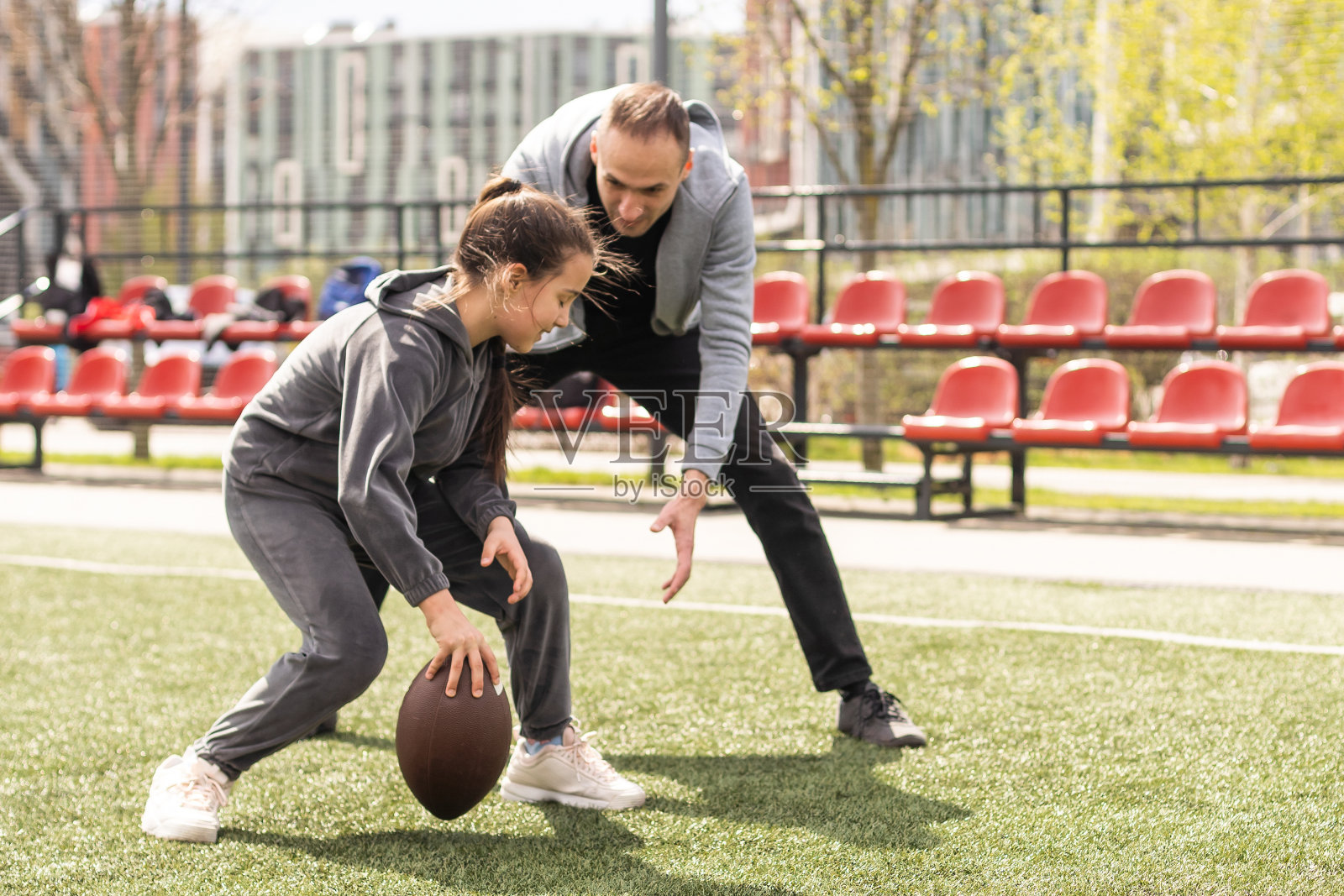 一家人在公园一起踢美式足球。照片摄影图片