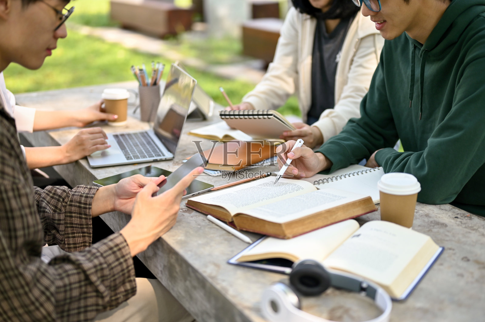 一群亚裔大学生准备考试,在校园公园做作业照片摄影图片