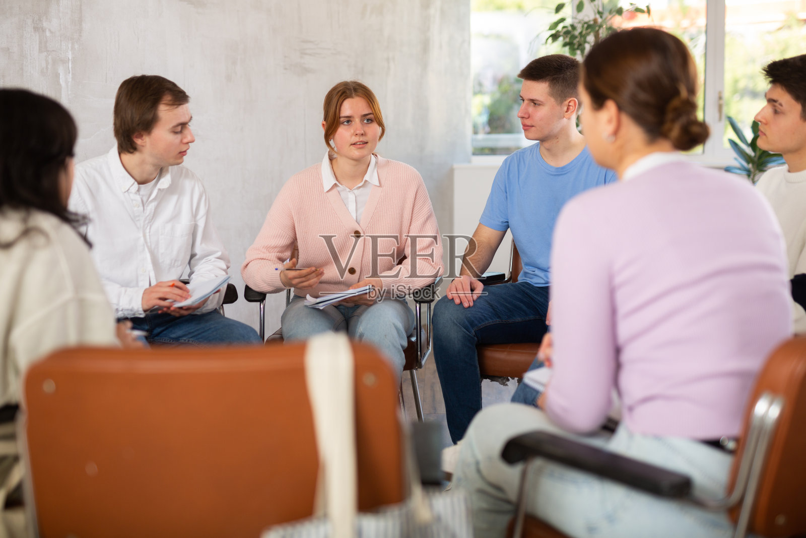 开朗的女生与同学讨论学习作业照片摄影图片