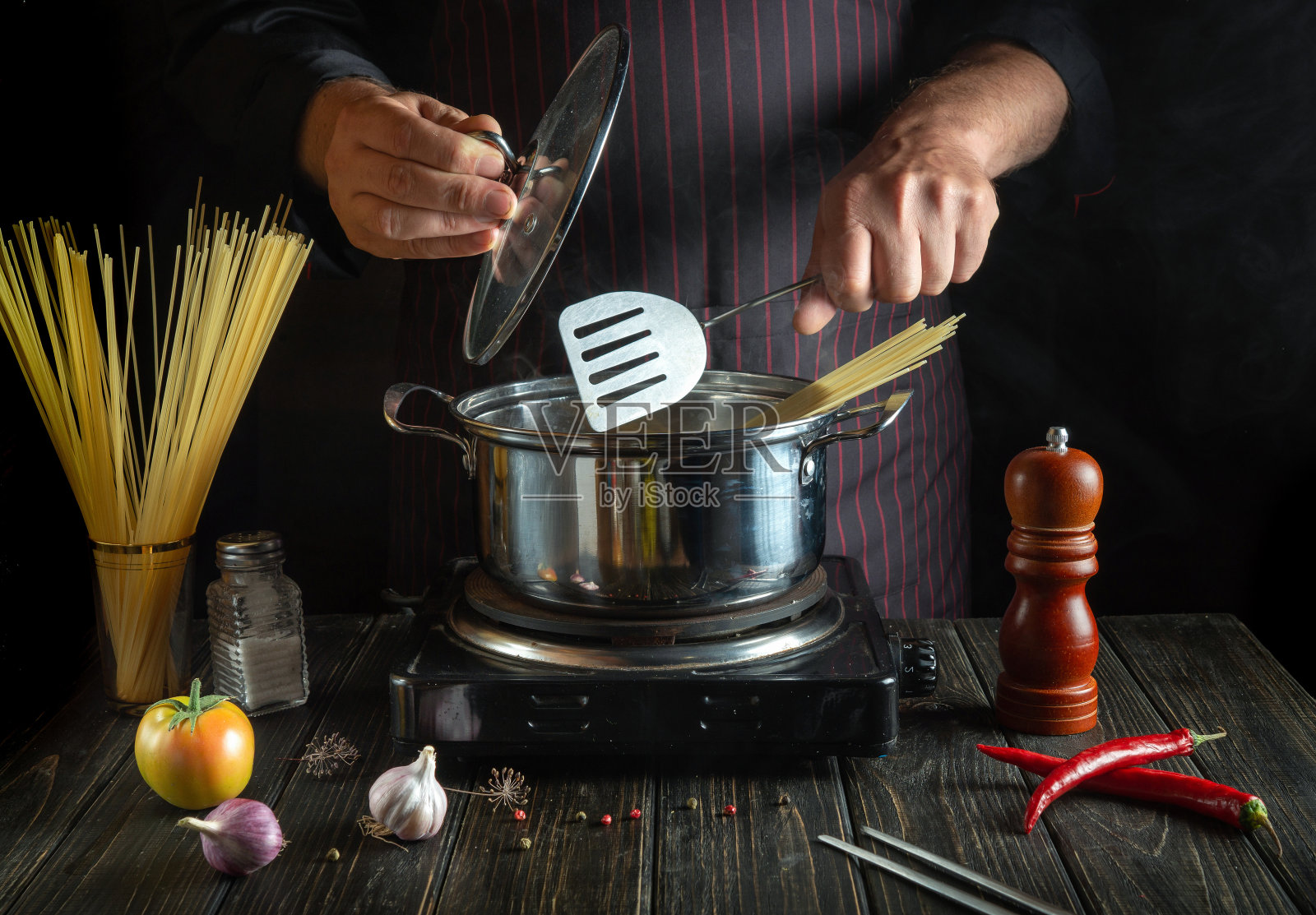 厨师用蔬菜在锅里煮意大利面。为餐厅或酒店准备美味午餐的食谱。国菜照片摄影图片