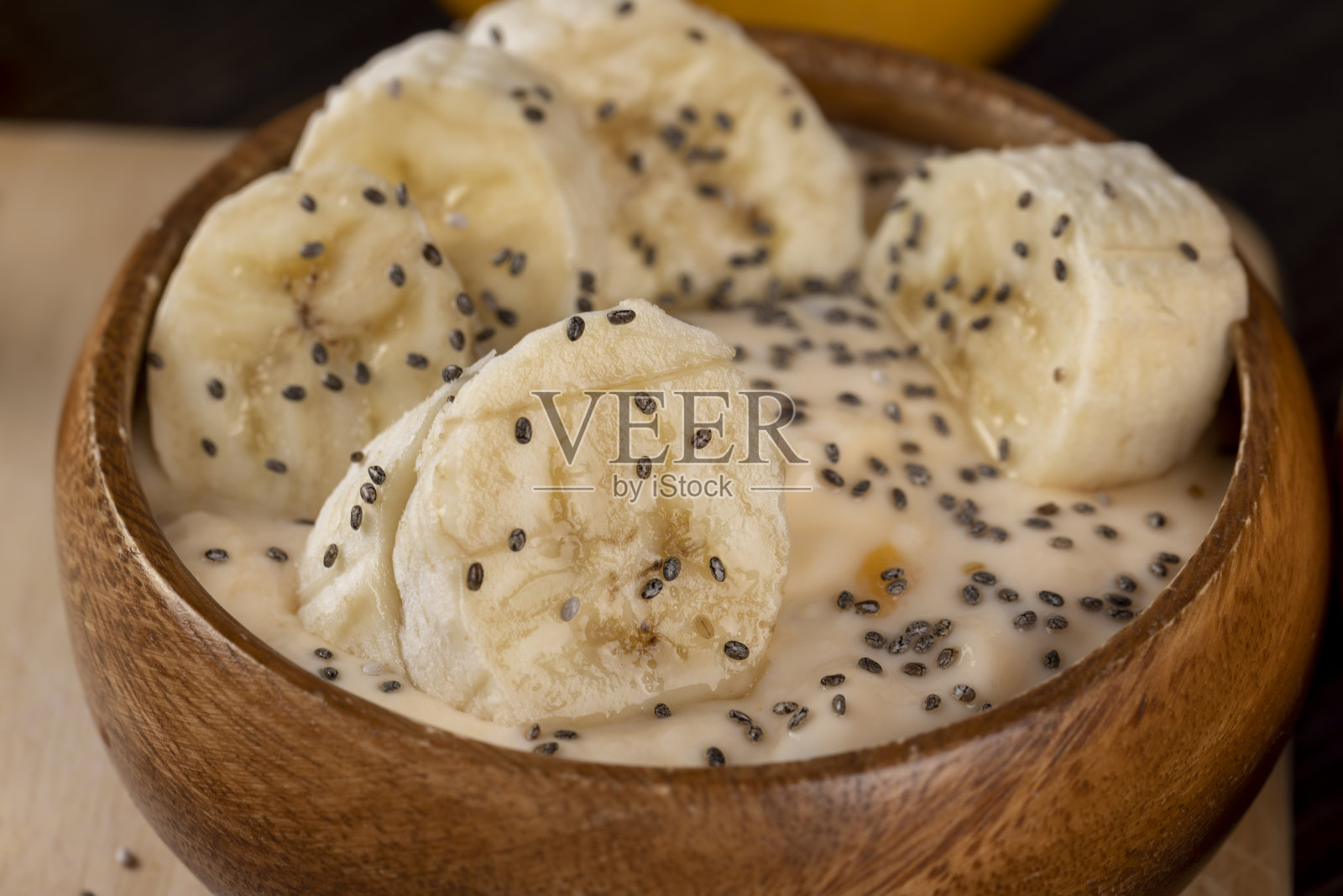 新鲜的香蕉味酸奶,配上撒有奇亚籽的香蕉片照片摄影图片