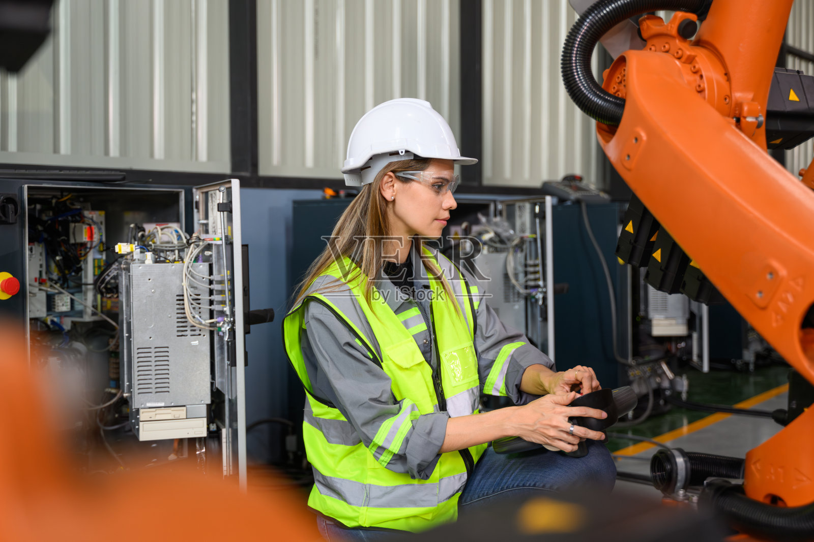 与自动化机器人一起工作的维修工程师照片摄影图片