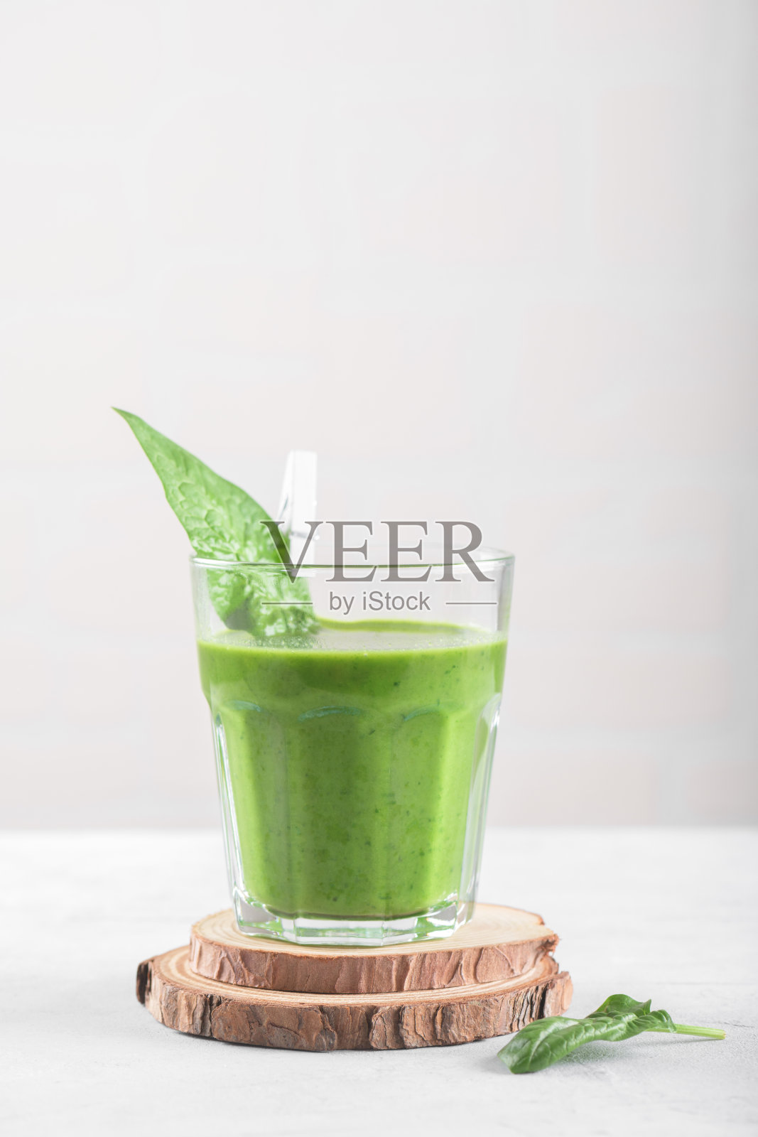 健康的绿色奶昔,菠菜,香蕉,和纯素牛奶在浅灰色背景的玻璃,复制空间照片摄影图片