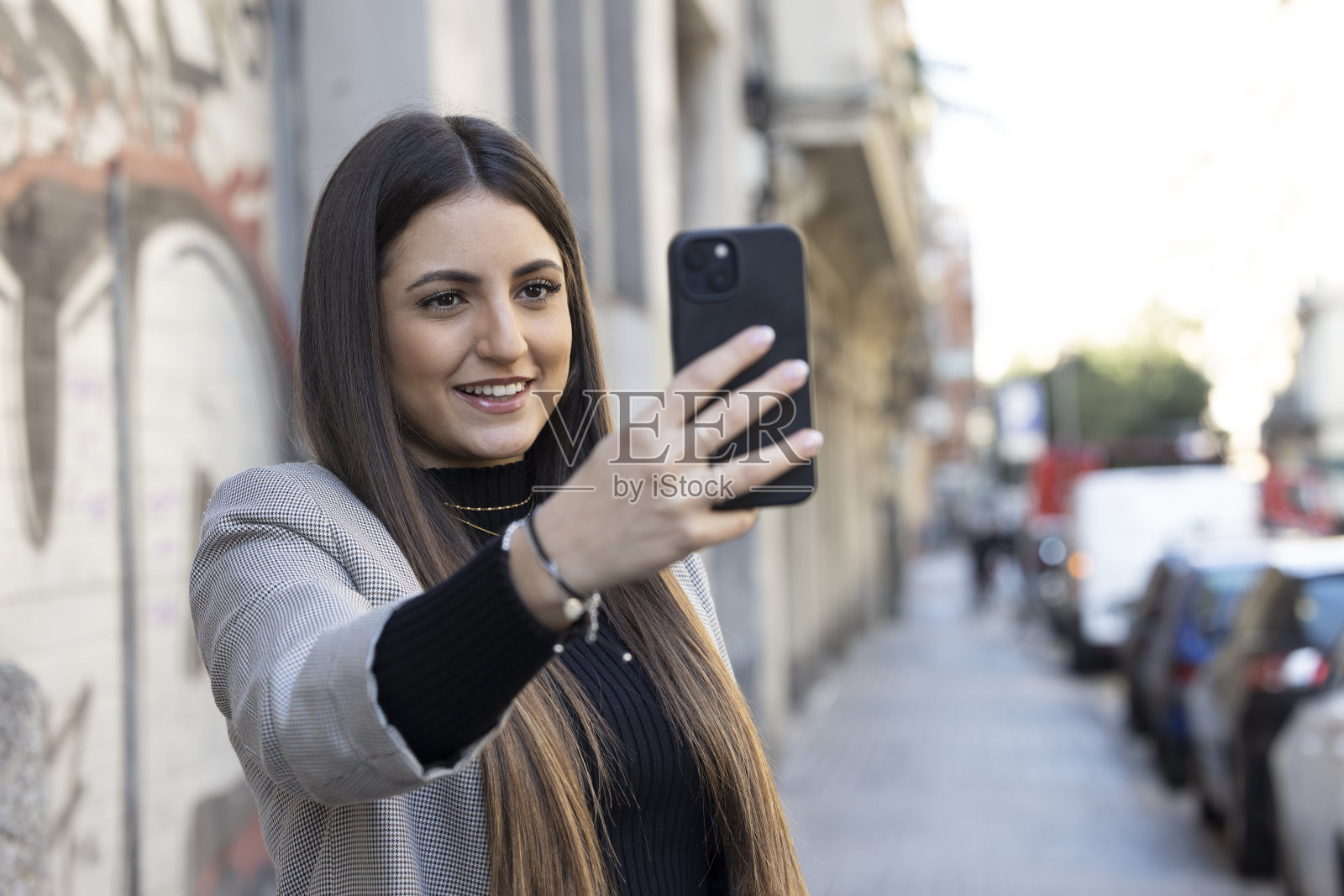 年轻女性,z世代,在巴塞罗那的城市环境中使用她的手机。照片摄影图片
