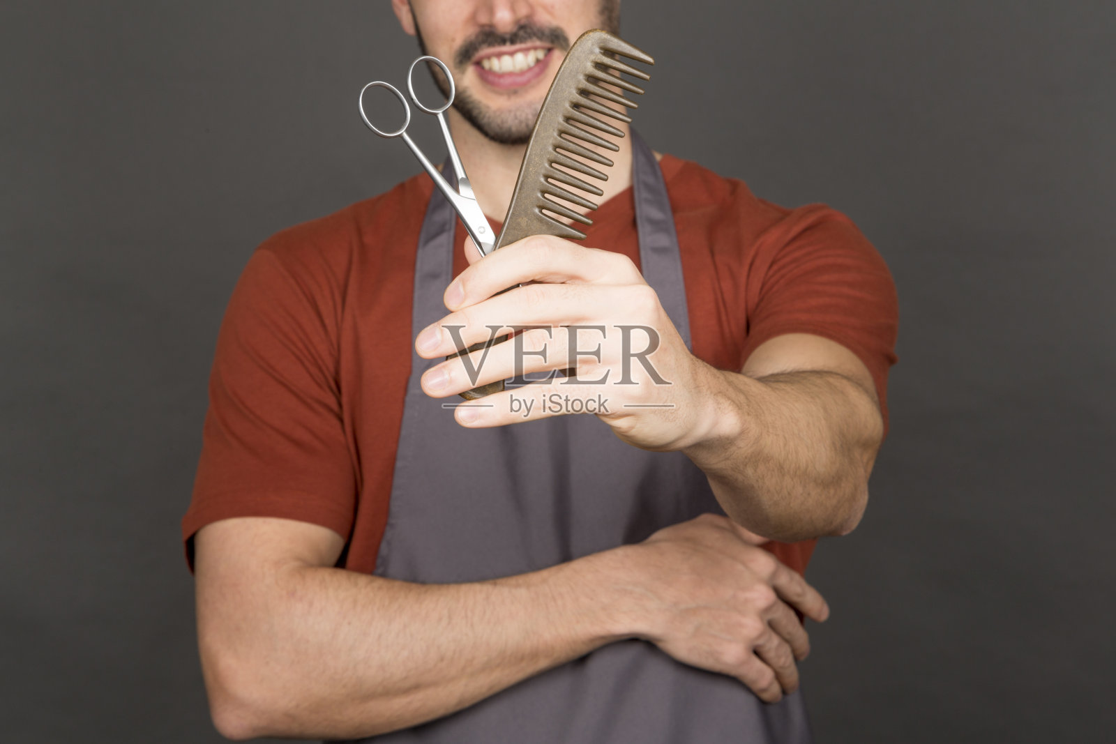 年轻男发型师用剪刀和梳子的特写照片摄影图片