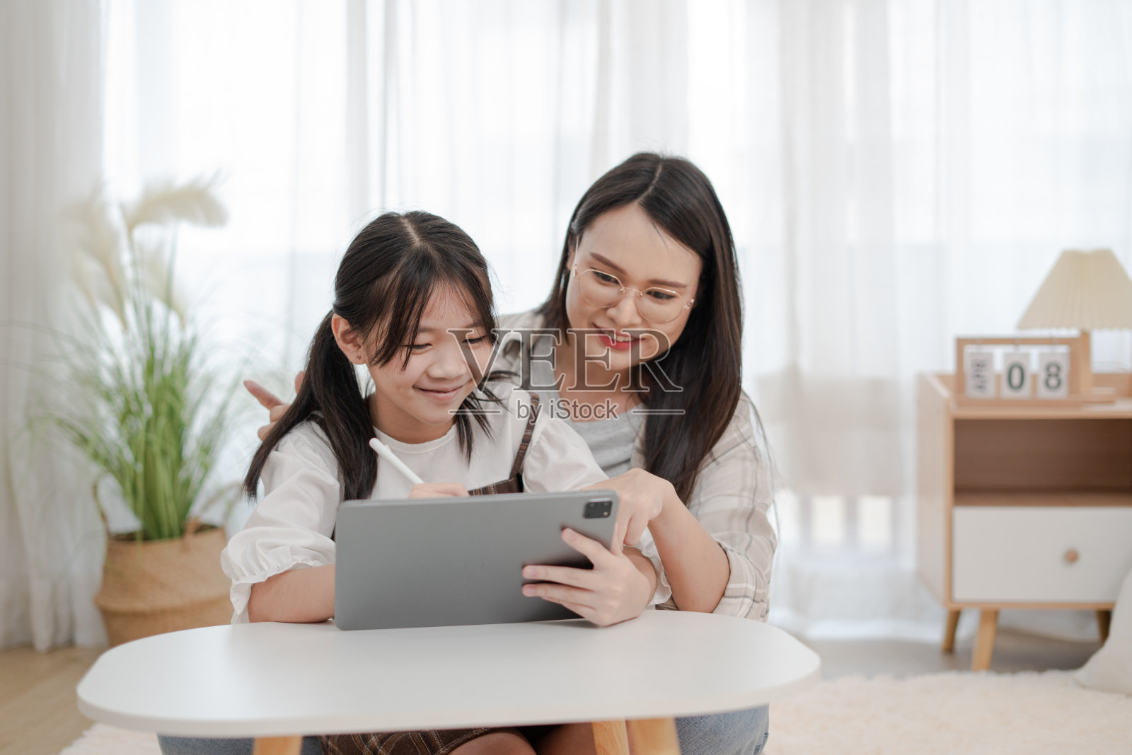 亚洲家庭的母女在家中使用平板电脑照片摄影图片