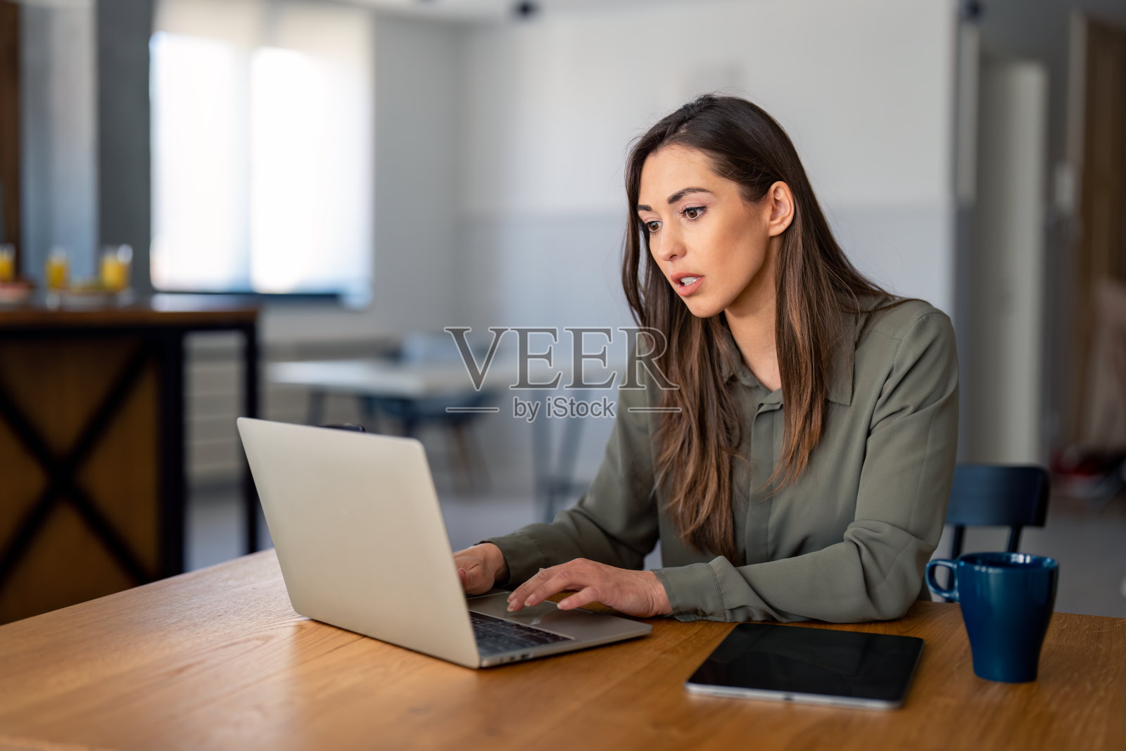 年轻专注的女商人使用现代科技便携式设备在家工作照片摄影图片