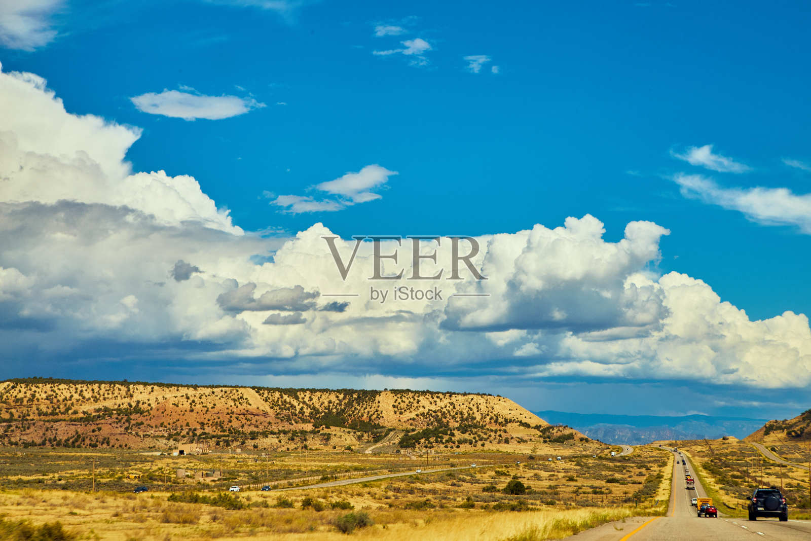 沙漠山脉上的云和蓝天,还有旅游汽车的高速公路照片摄影图片