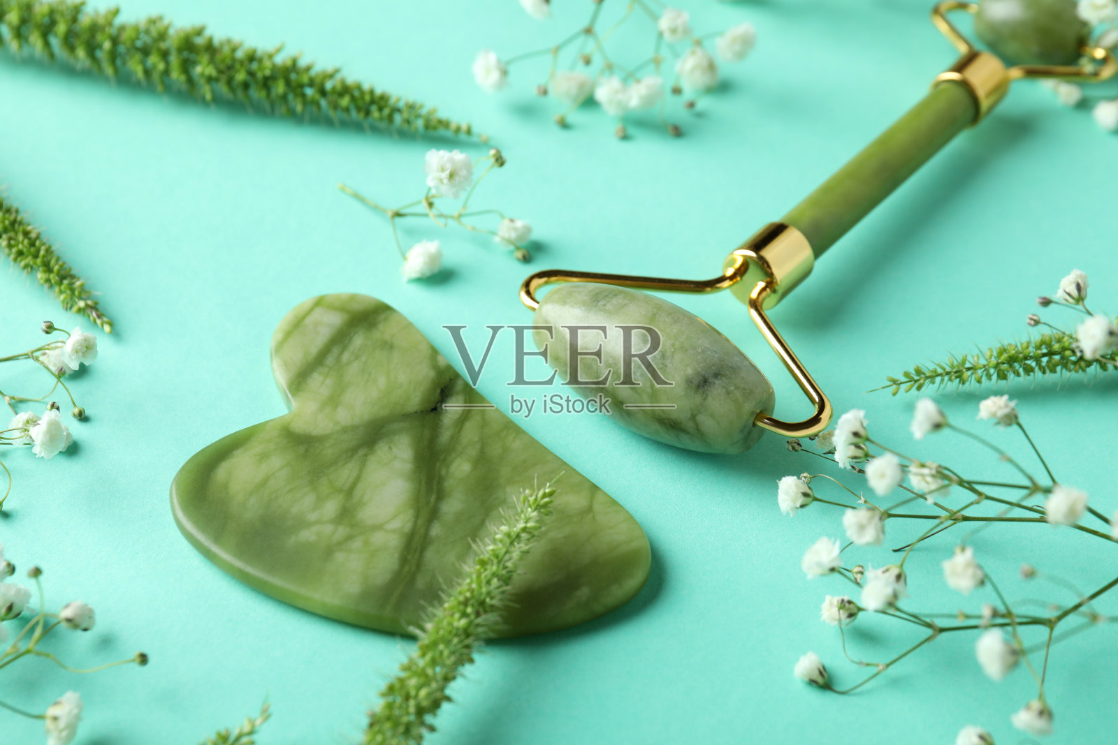 以薄荷为背景的护肤理念:脸部滚轮和刮痧照片摄影图片