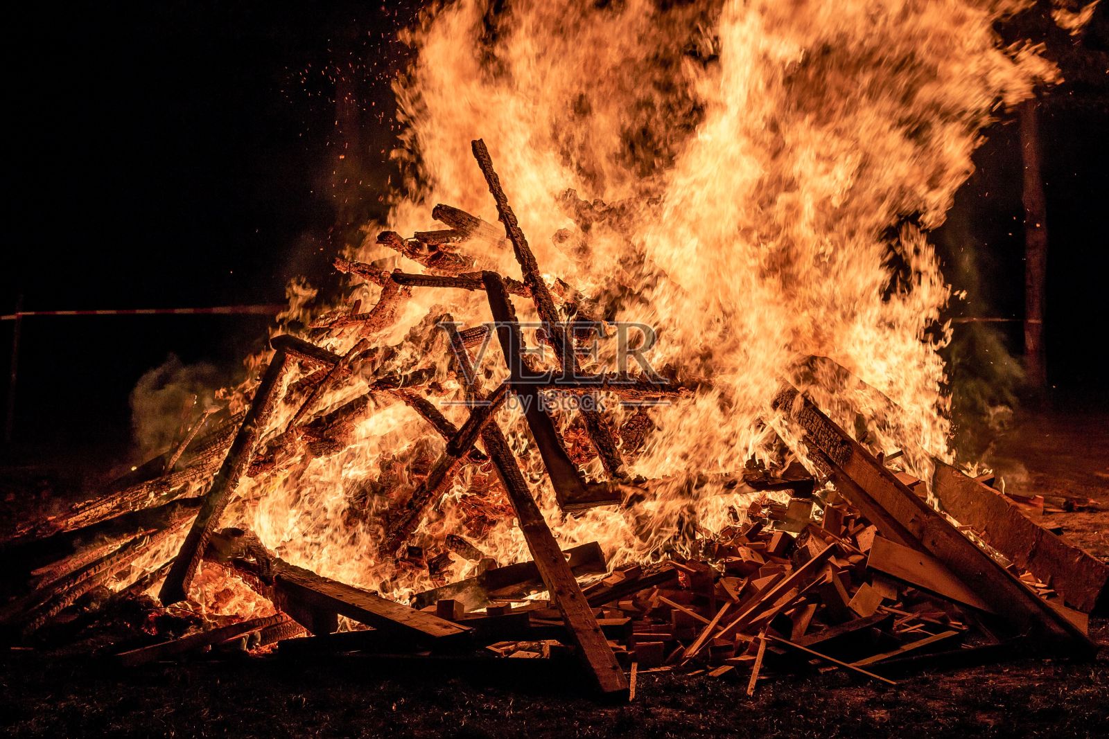 明亮的橙色火焰在黑暗的背景下熊熊燃烧照片摄影图片