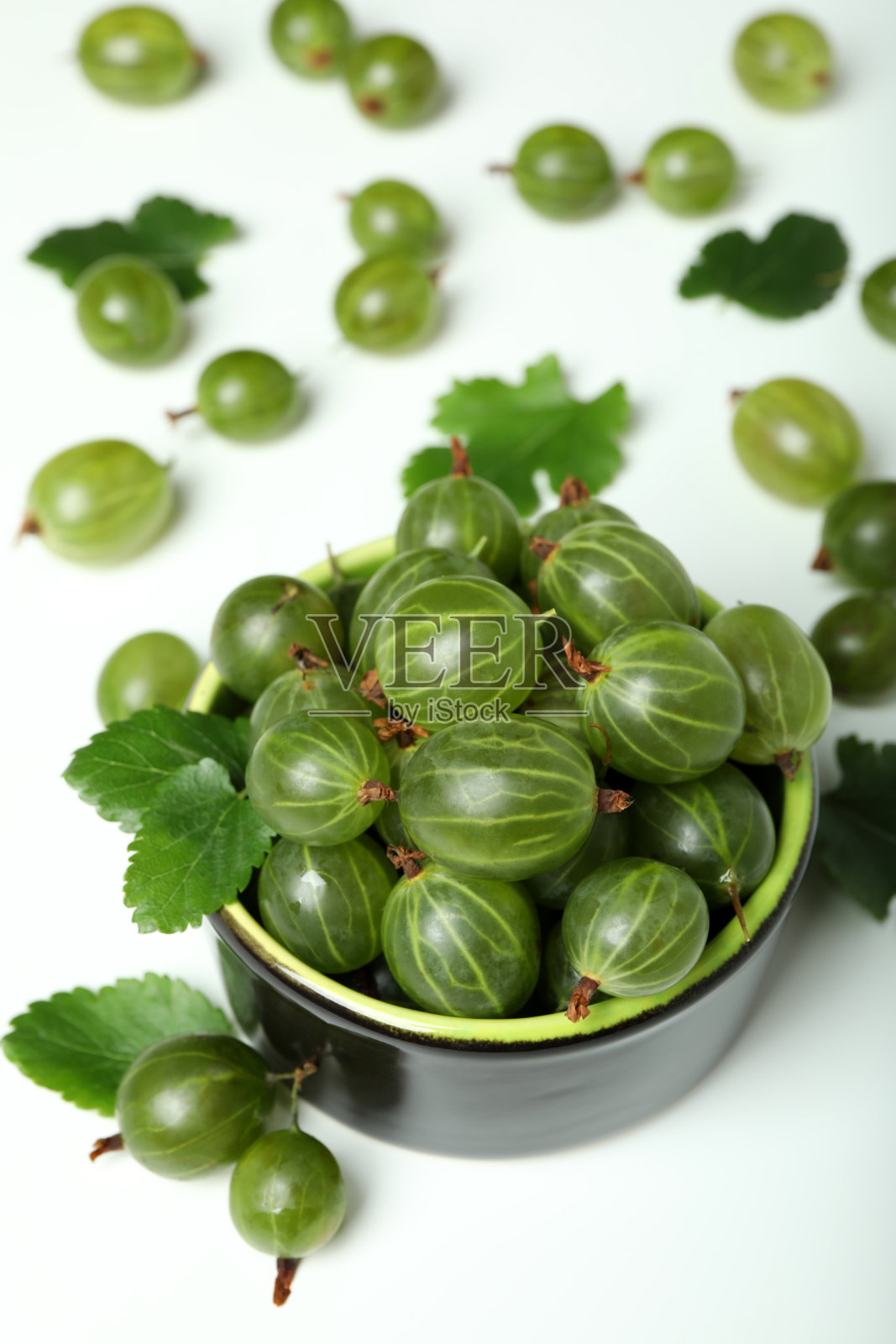 一碗成熟的醋栗在白色的背景下照片摄影图片