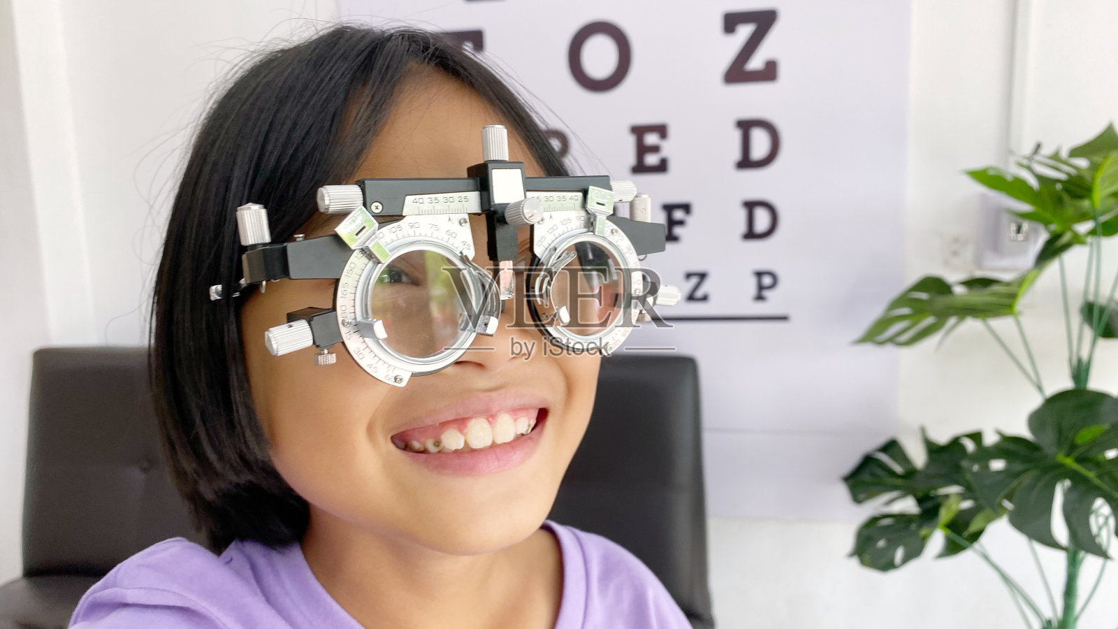 眼科检查,儿童配戴眼镜进行眼科检查,眼科检查,眼科检查概念,儿童眼科检查照片摄影图片