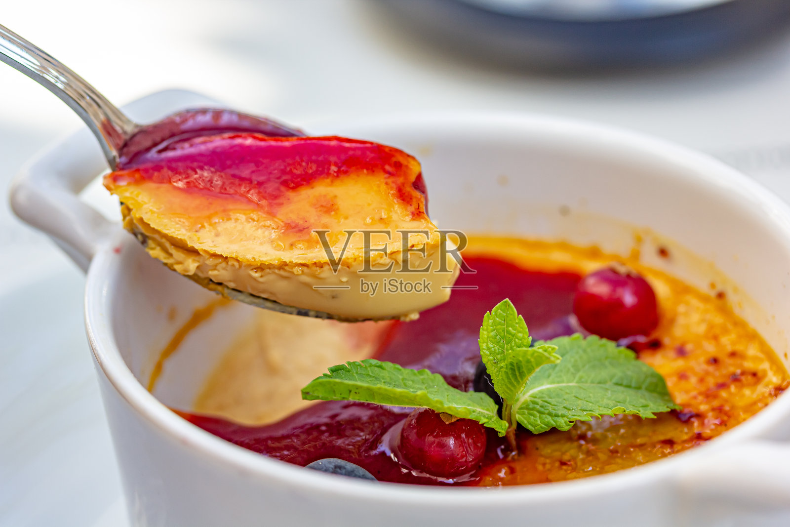 甜点焦糖布丁或加了薄荷叶和浆果的加泰罗尼亚奶油照片摄影图片