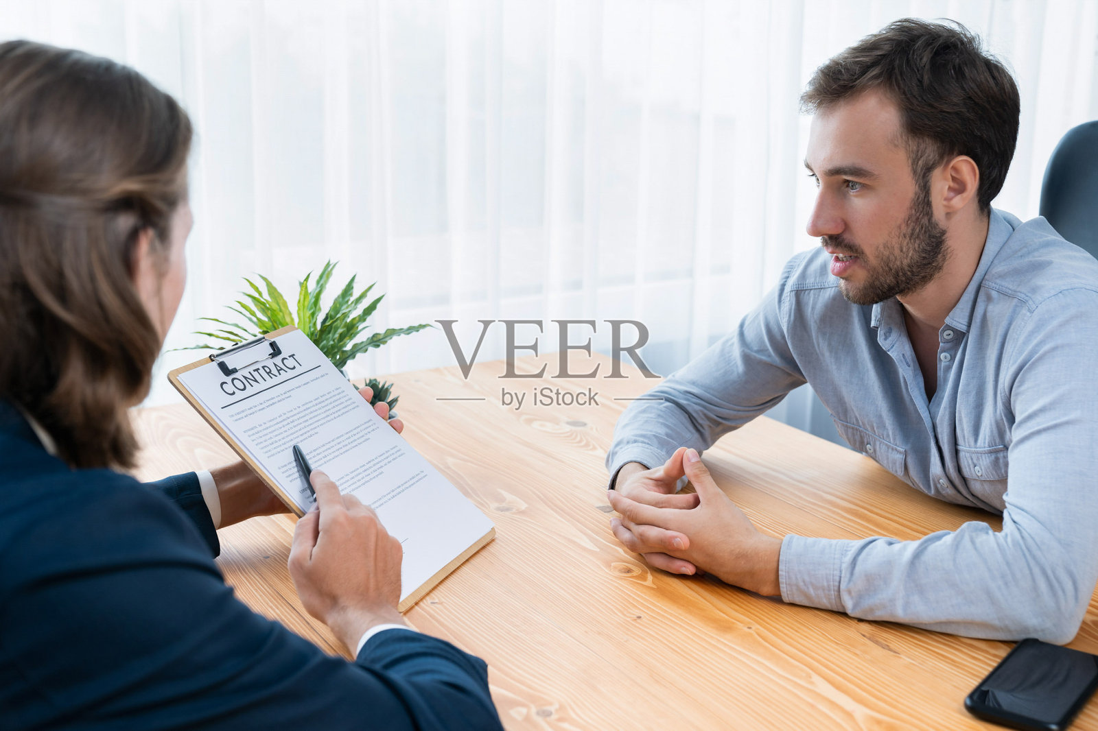 商人或客户仔细审阅合同文件。实体照片摄影图片