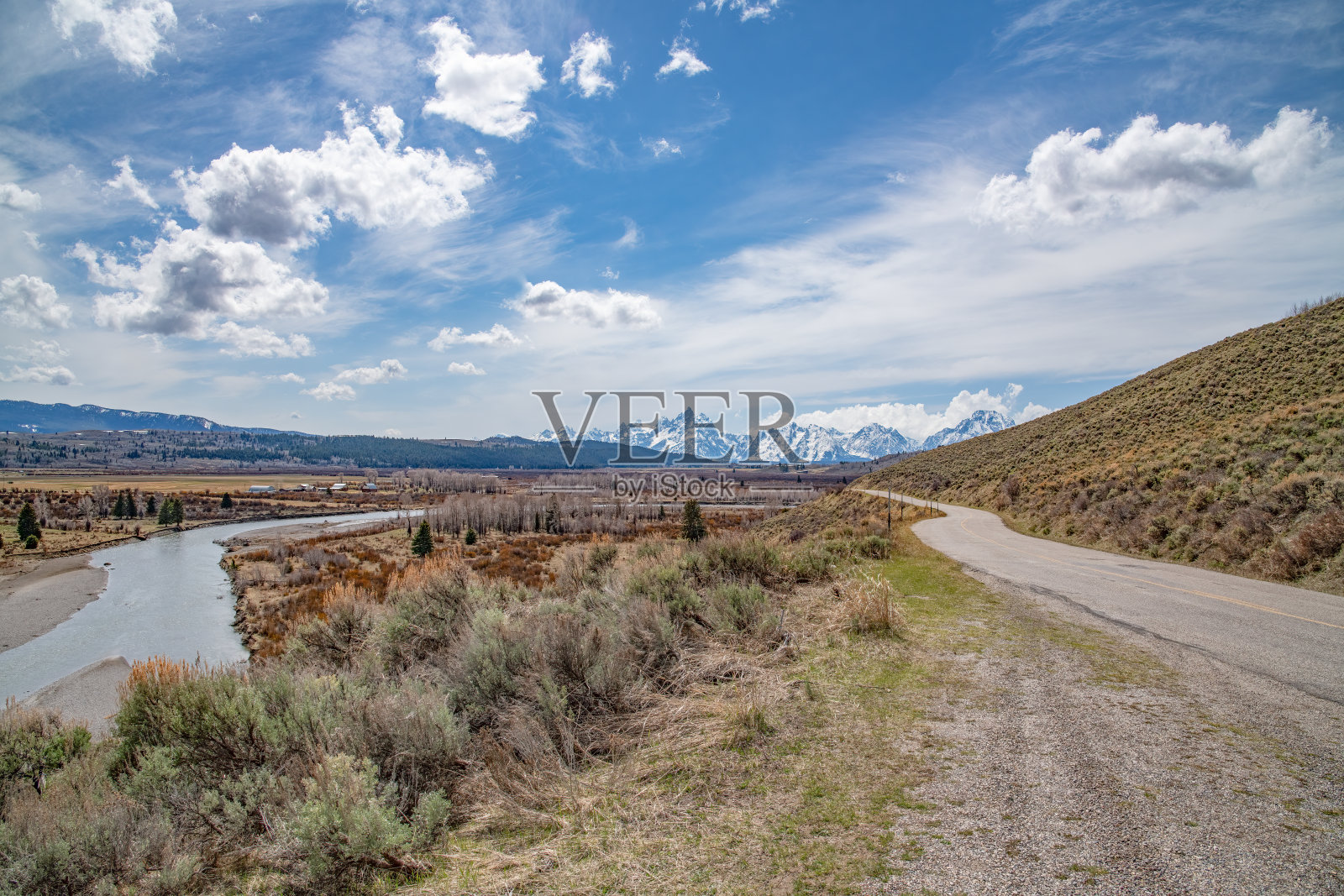 在美国西部,北美黄石生态系统的大提顿宽阔的山景与道路和河流照片摄影图片