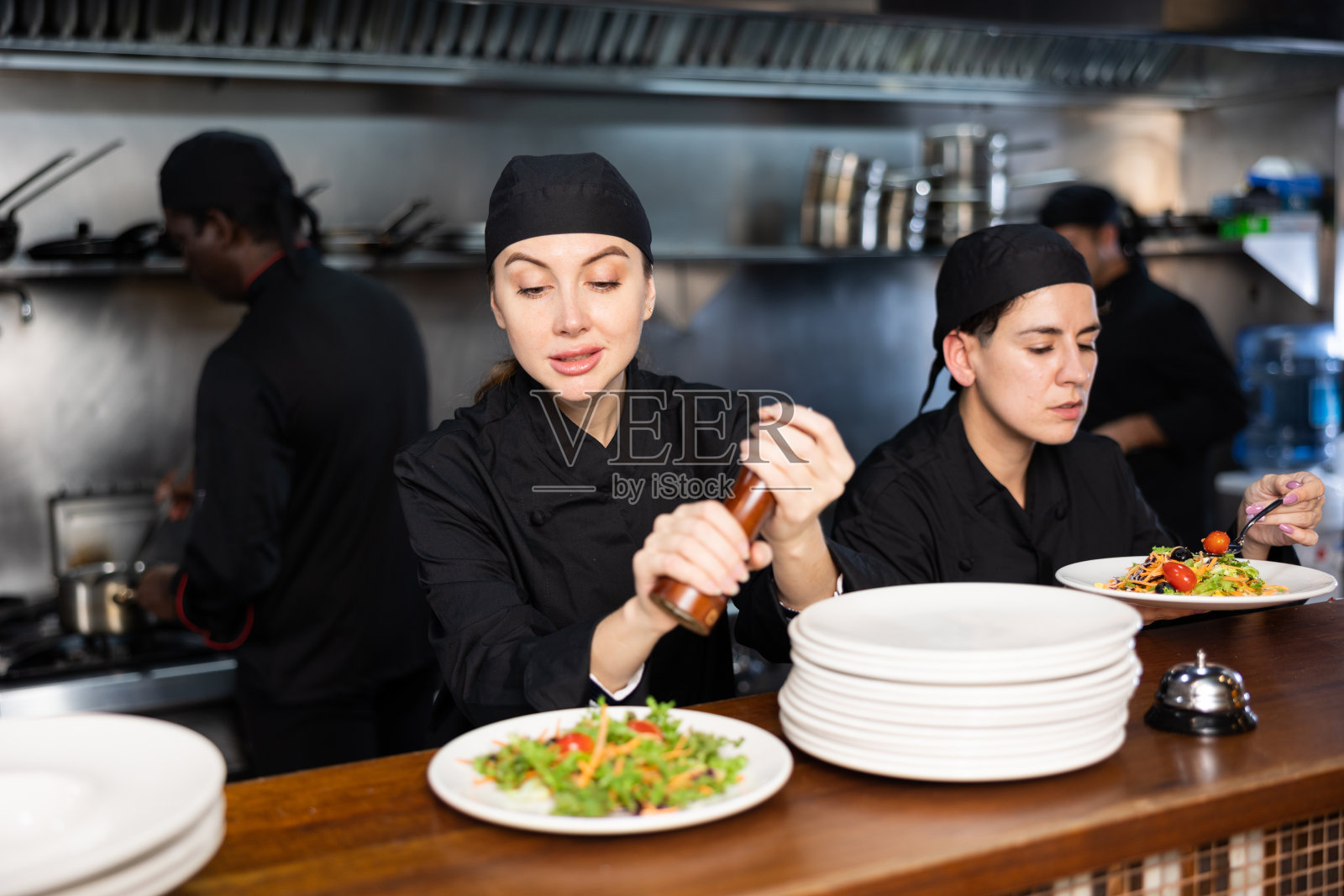 女厨师在上菜前给沙拉调味照片摄影图片