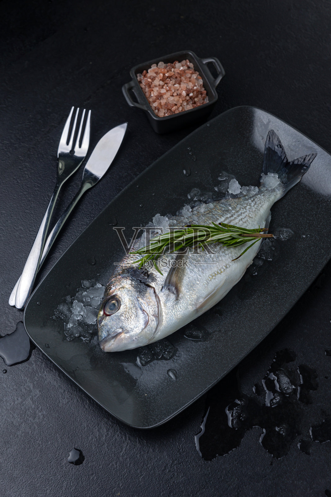 黑色盘子里的生鱼照片摄影图片