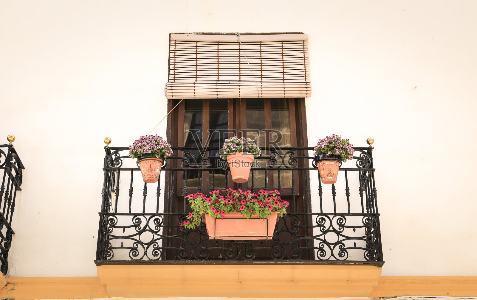 外墙刷成白色,有阳台和五颜六色的花盆照片摄影图片