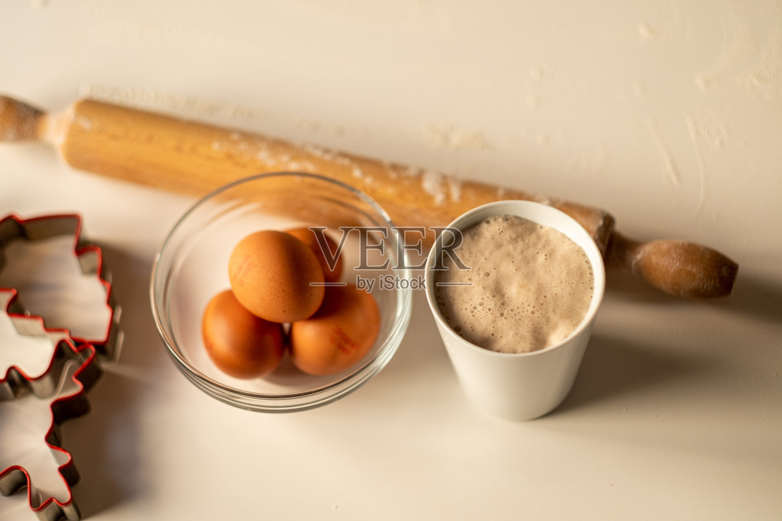 鸡蛋,擀面杖,酵母和面粉放在桌子上照片摄影图片