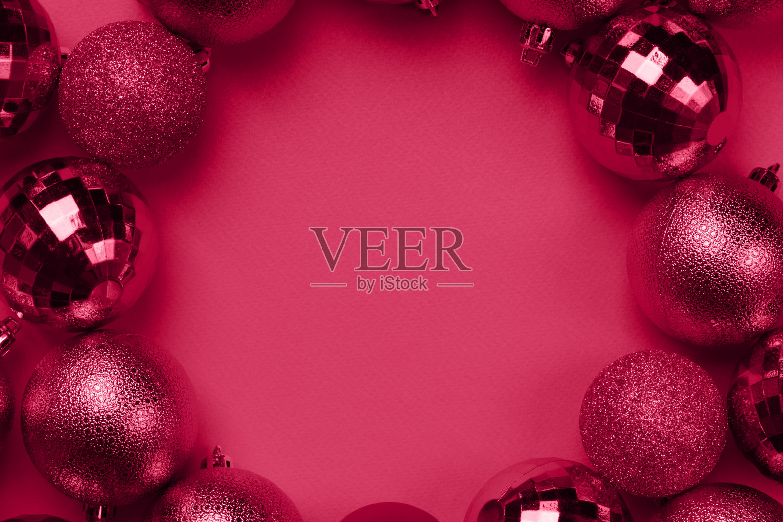 在胭脂红的背景上,活泼品红圣诞球的圆形框架照片摄影图片