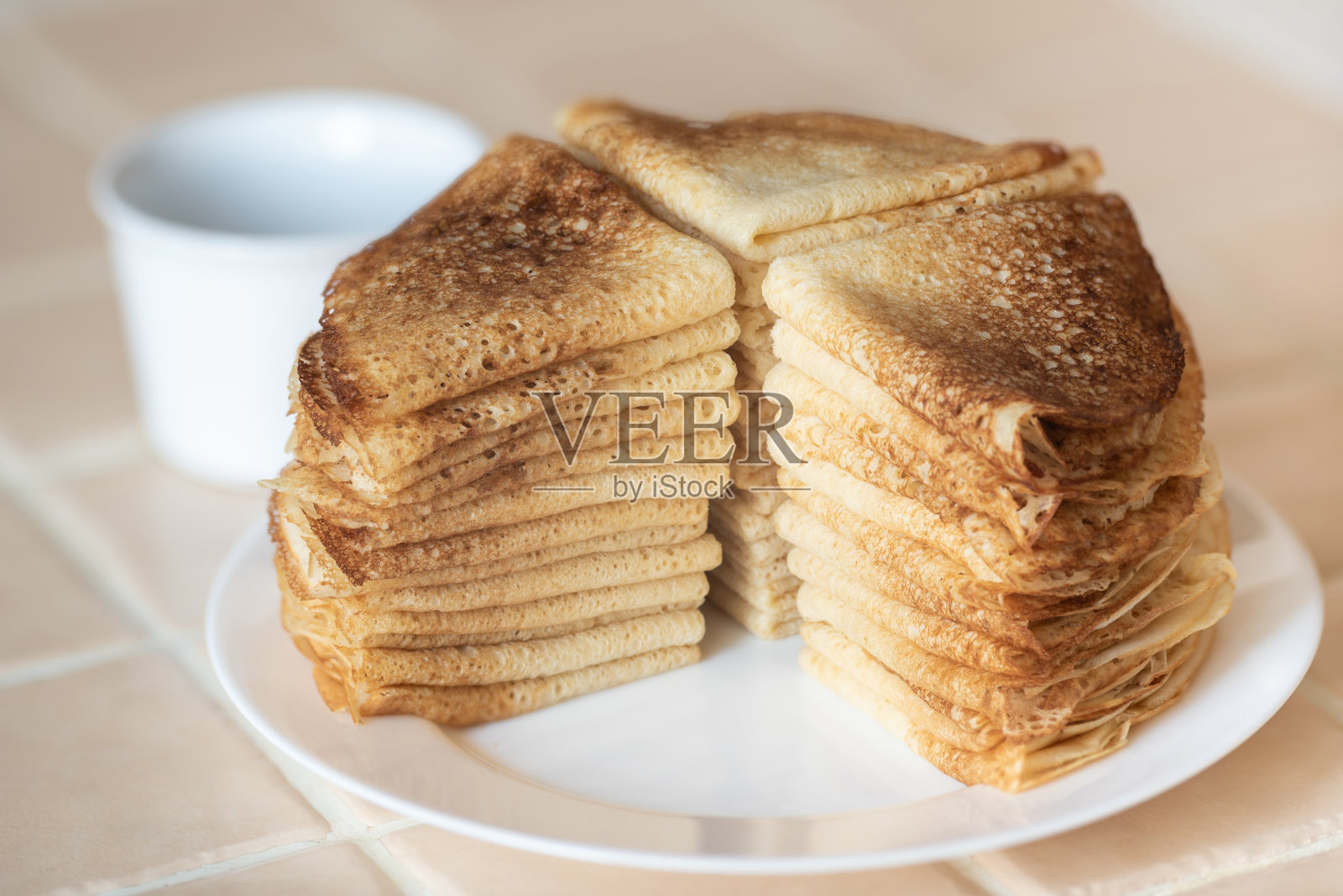 白色盘子里的一叠自制煎饼。照片摄影图片