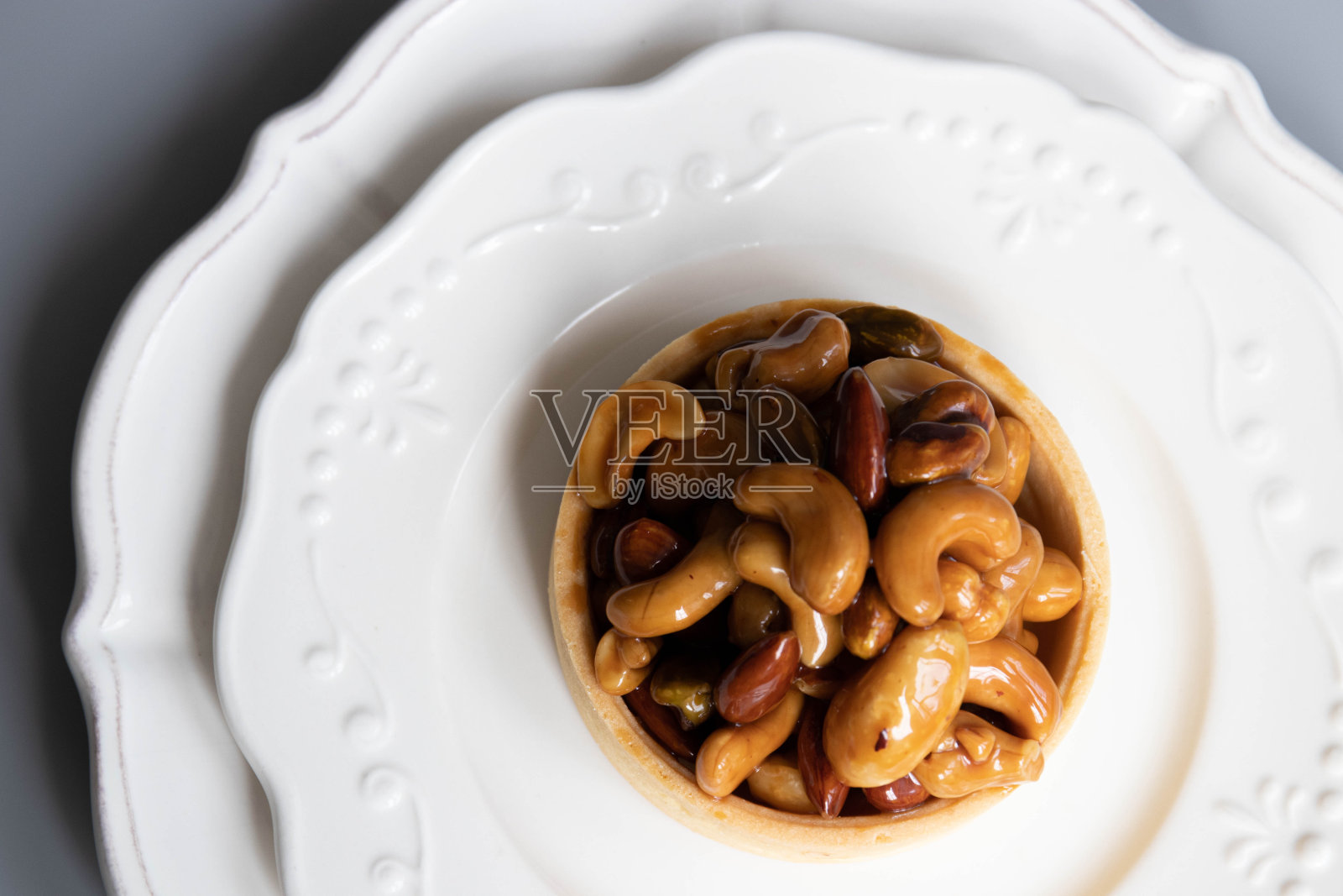 特写焦糖坚果馅饼在灰色背景照片摄影图片