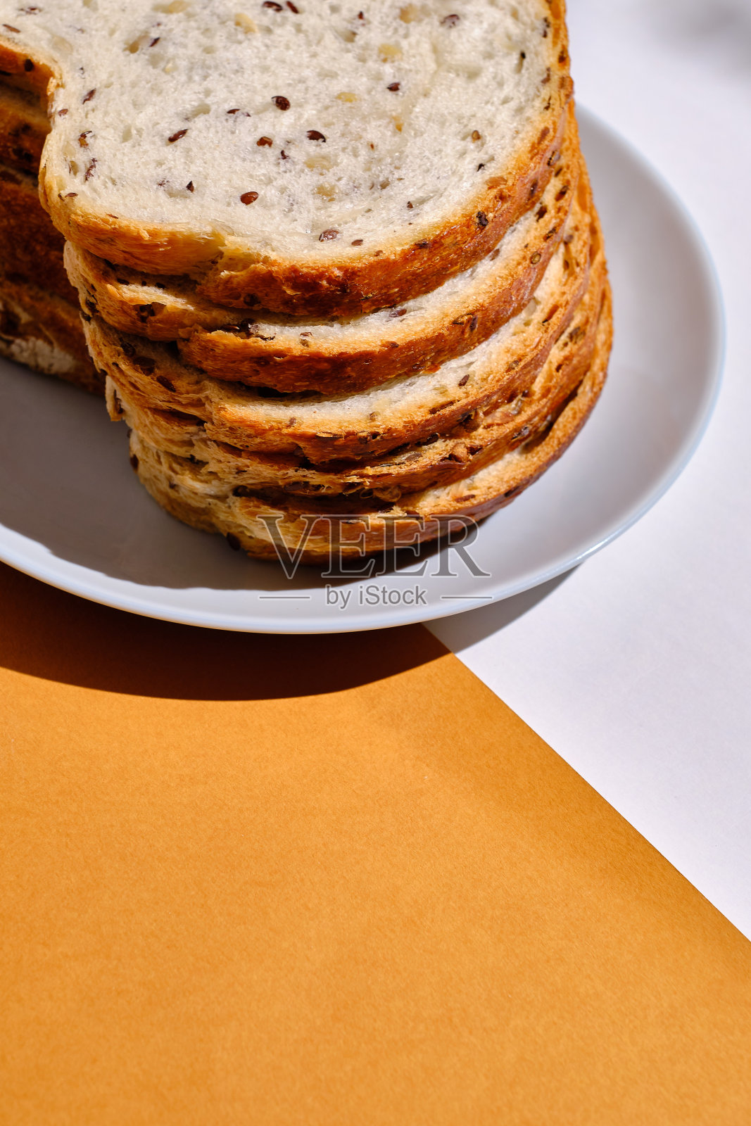 在浅色背景的盘子里放着新鲜的切片面包和烤面包。甜的糕点。食物与营养概念照片摄影图片