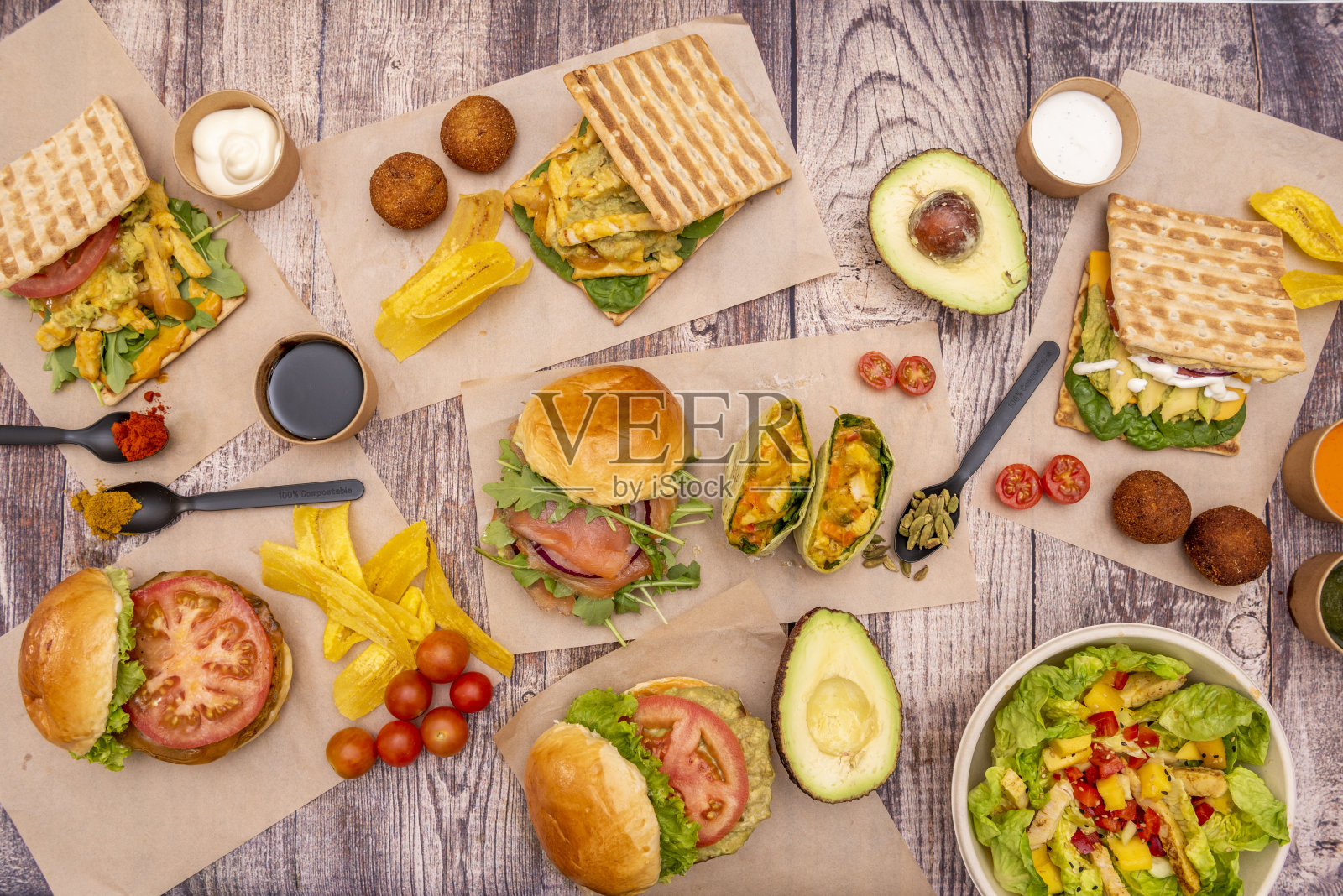 健康的快餐菜肴,包括各种蔬菜,鱼和鸡肉汉堡,小吃丸子和水果和蔬菜沙拉照片摄影图片