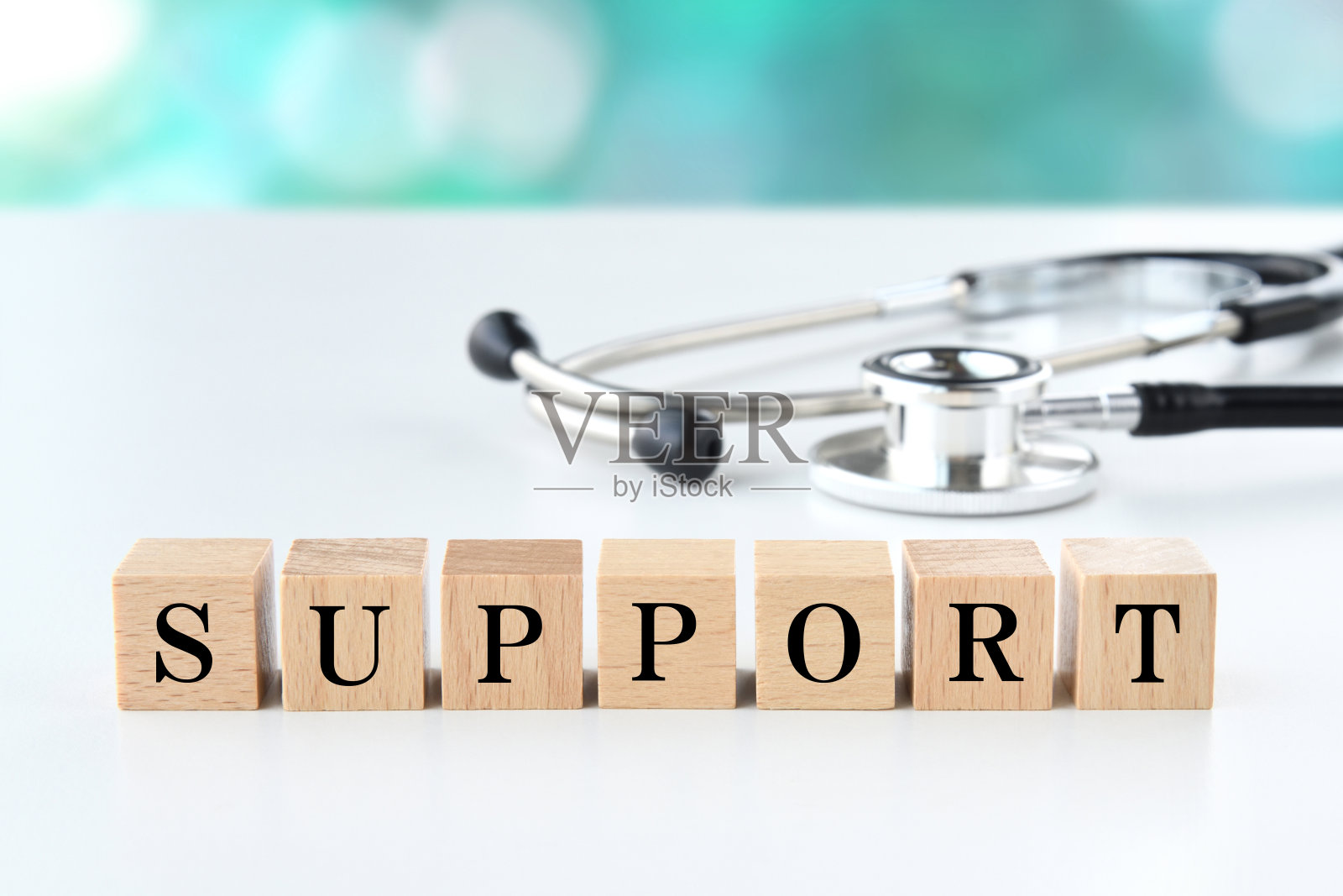 听诊器和带有支持字的木块照片摄影图片